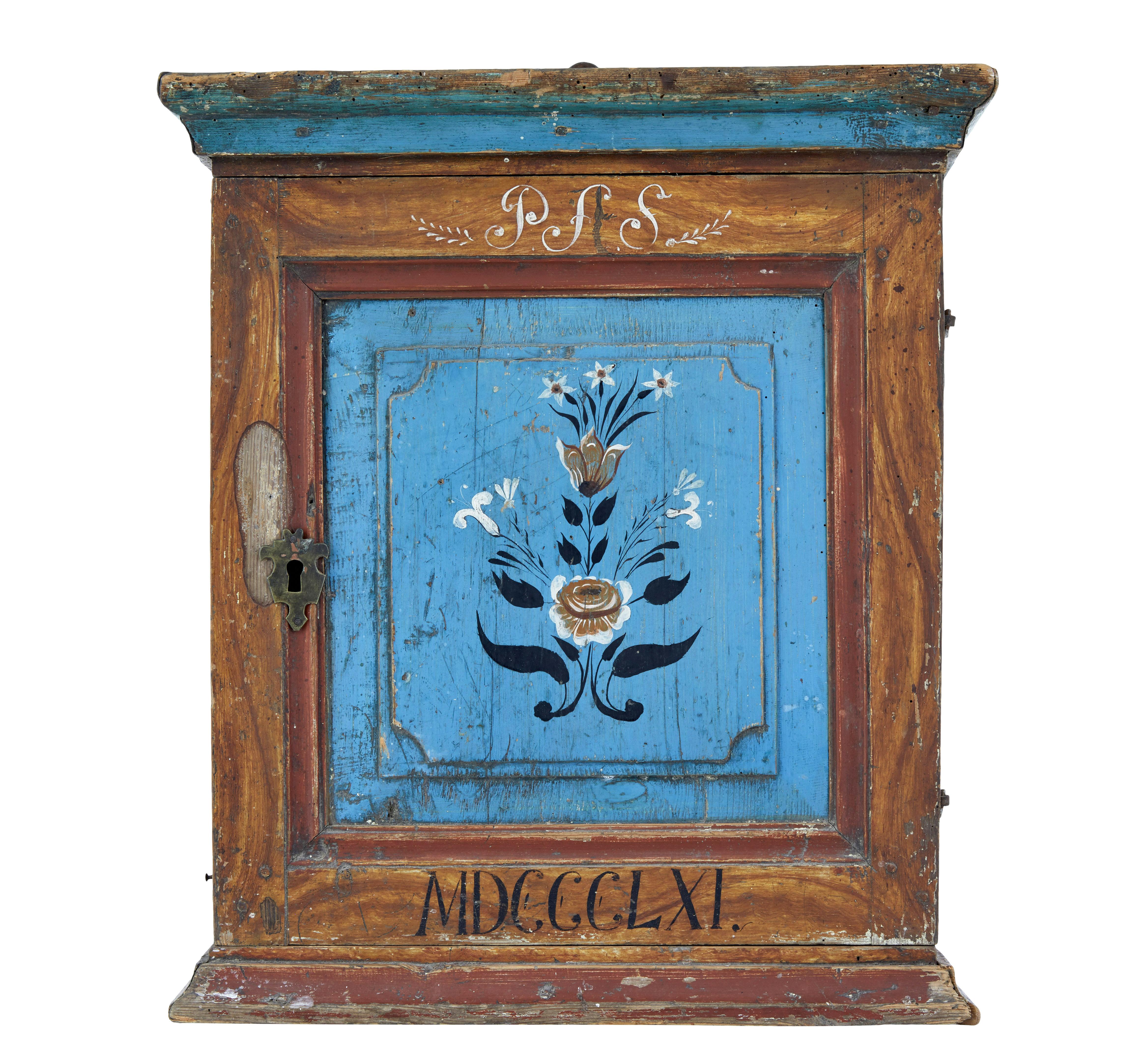 Hand painted mid 19th century swedish pine wall cupboard circa 1861.

Good quality traditional hand painted swedish wall cupboard.  Made from pine and painted in a blue/orange and russet red scheme.  Cornice edged to top and bottom.  Hand painted