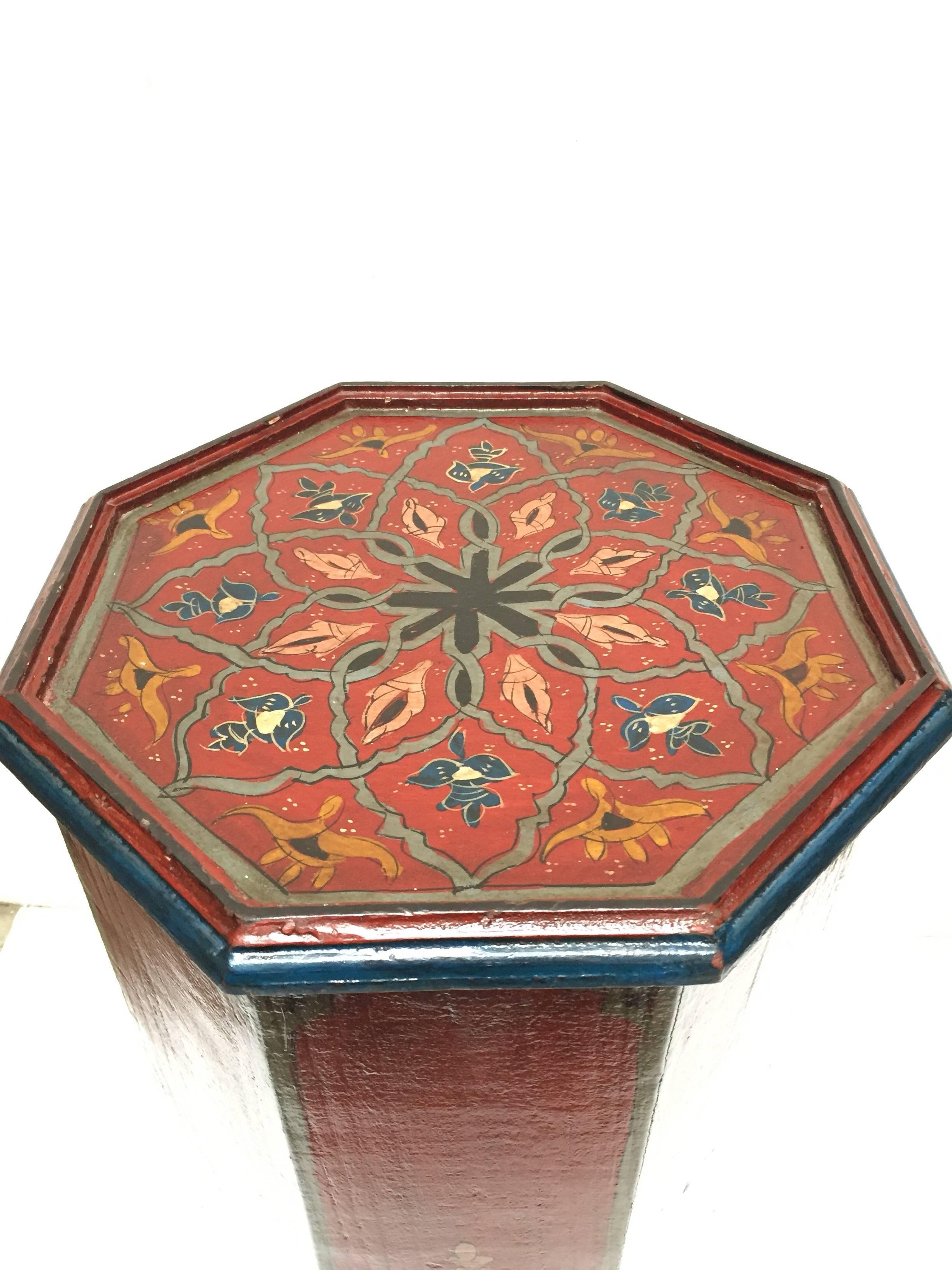Moroccan vintage pedestal table, hand-painted on a dark maroon background color with floral and geometric designs in blue and yellow colors.
Moorish arches on the base of these octagonal shape table.
African folk Art handcrafted by skilled artisans