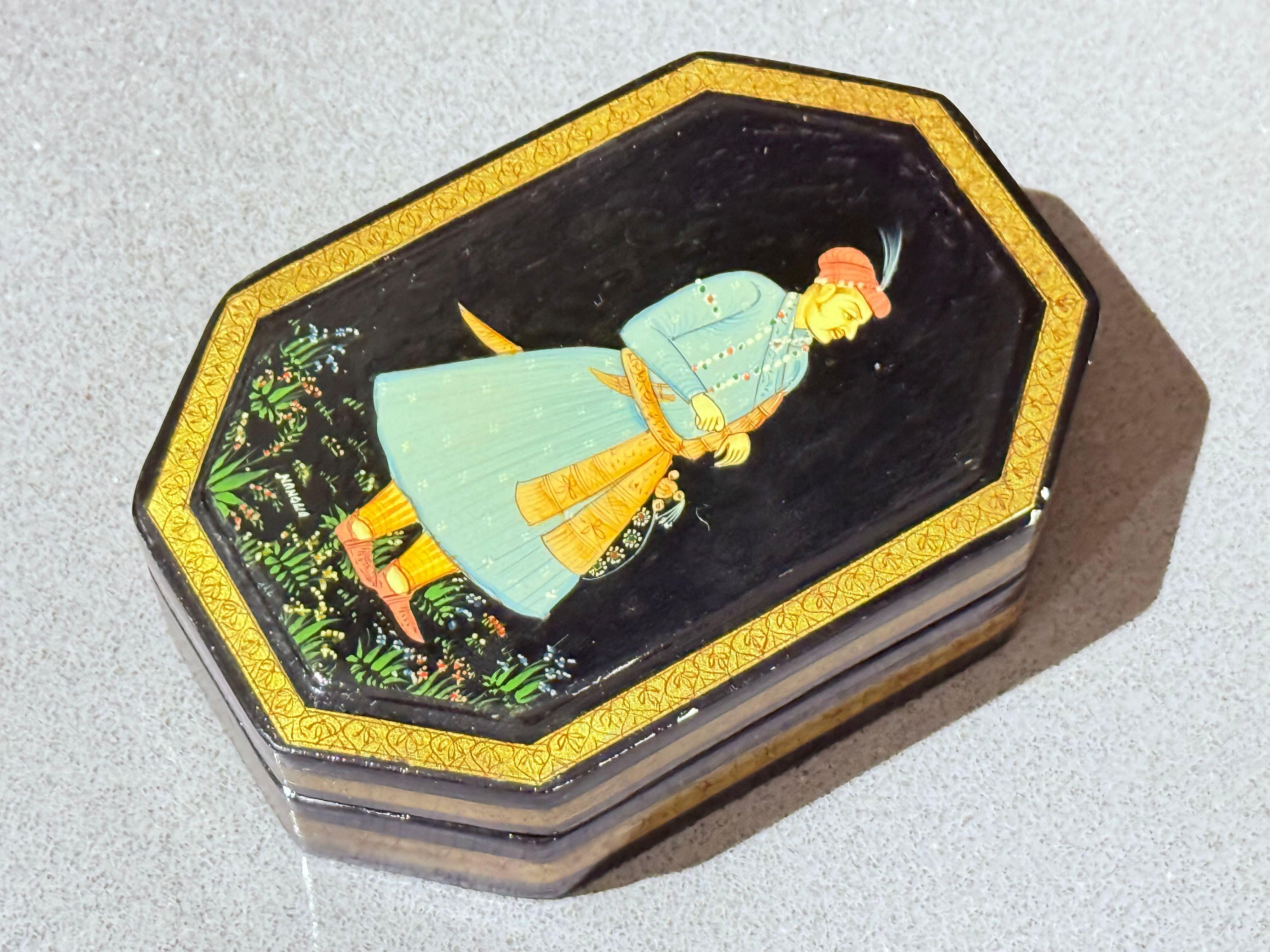 A superbly hand-painted Mughal miniature lacquer box, created in the refined Indo-Persian artistic tradition and signed “Nangua”. This exquisite octagonal decorative box features a finely detailed portrait of a Mughal nobleman in a turquoise robe,