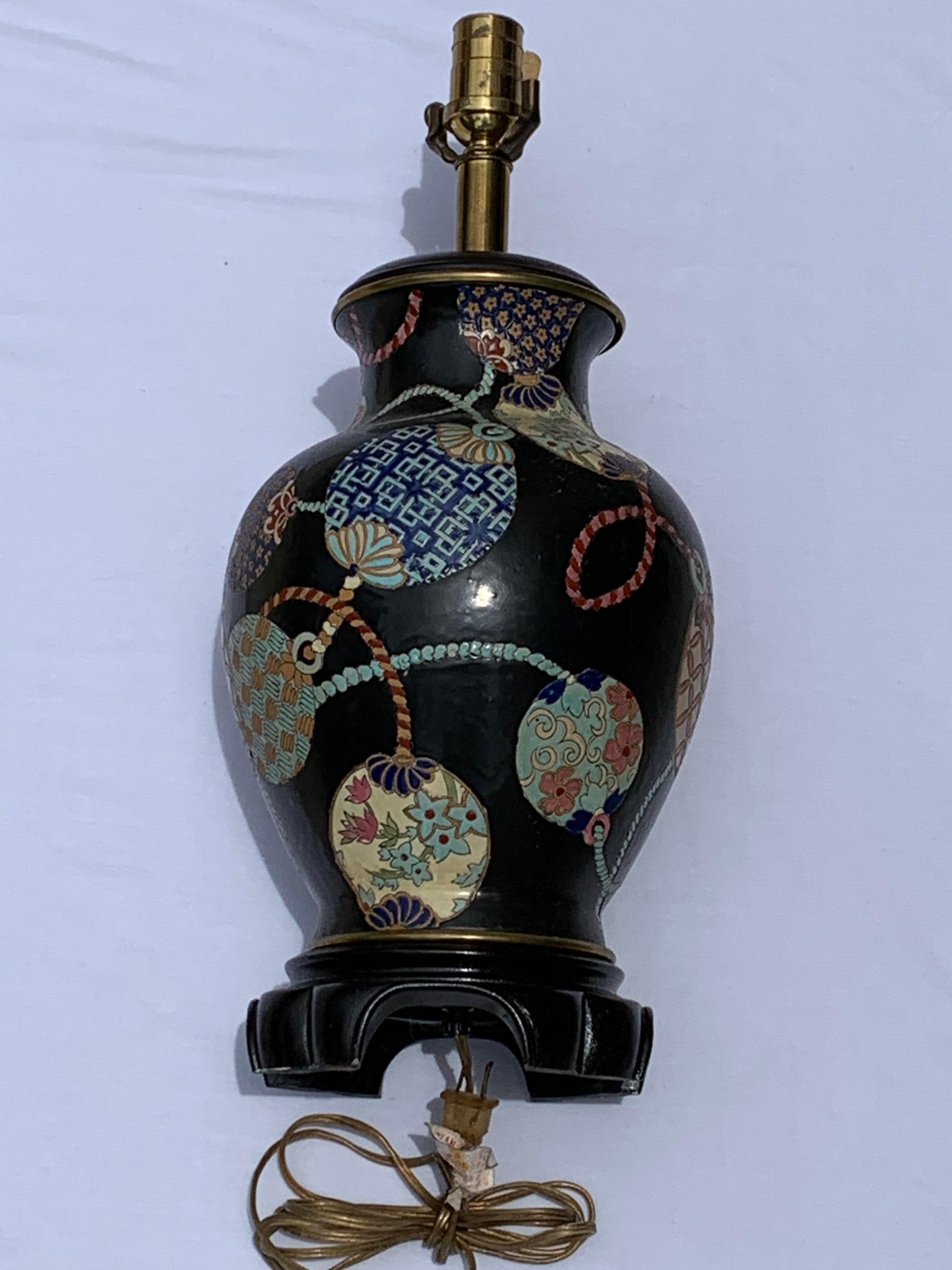 Decorative vintage Chinese table lamp made of ceramic, hand painted with colorful geometric and floral motifs all around on black background. One 150/watt maximum light, mounted on elegant base, shade is not included.
Measures: Height of the lamp