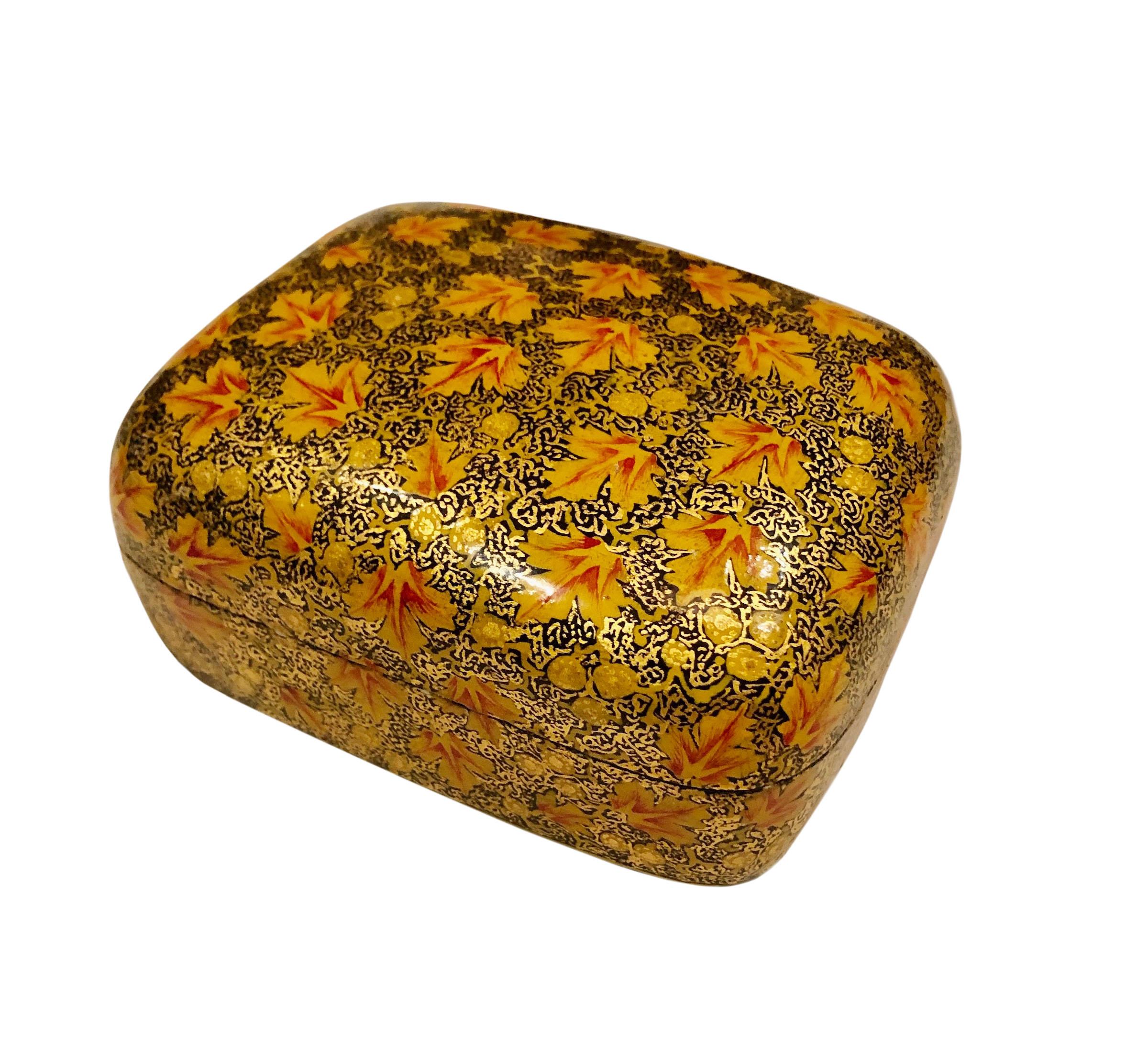 A 1960s hand painted papier mâché box with a domed top from Kashmir India. The box is orange and gold hand painted papier mâché with a white interior the bottom is black.
 
