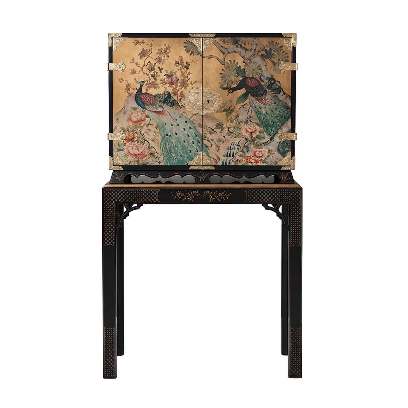 A finely hand-painted and black lacquered cabinet on stand, the cabinet with gold leaf and hand-painted decoration of peacocks in a landscape, with fine repousse chased brass mounts, on a base with chamfered legs and fretwork spandrels hand-painted