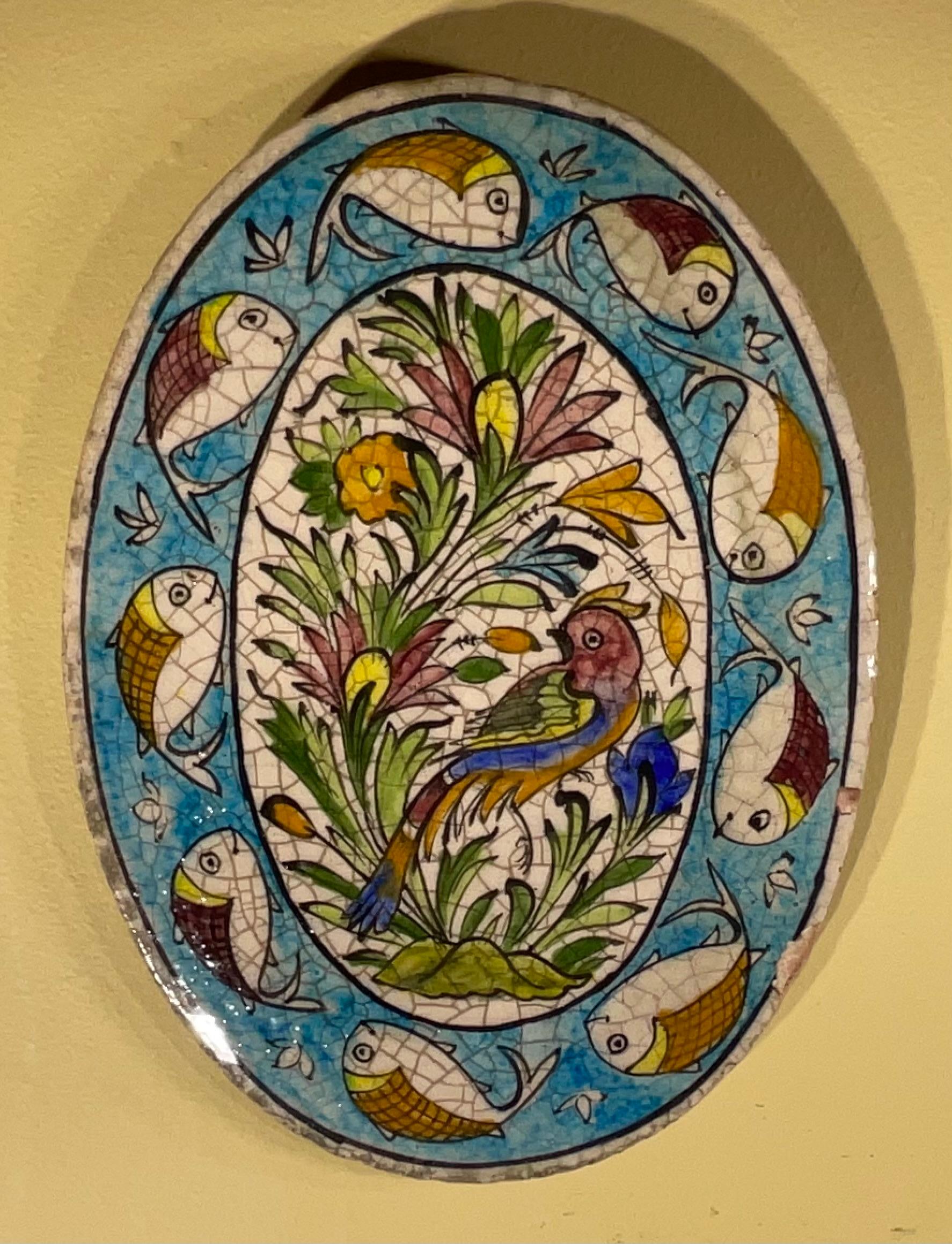 Entrez dans le monde captivant de l'art persan avec ce magnifique carreau de céramique peint à la main. Ce carreau ovale unique présente un design vibrant et méticuleusement détaillé, mettant en valeur une riche tapisserie de fleurs épanouies,  et
