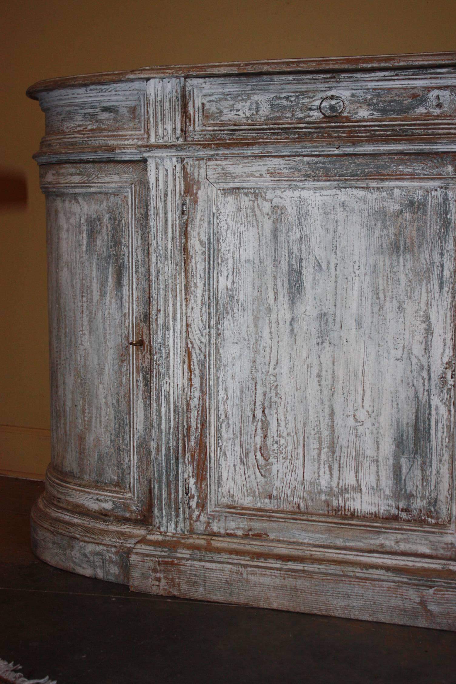 Italian painted buffet with clean lines and beautifully carved details having four separate storage compartments and two drawers above. This is a beautiful light white and French blue painted piece with natural wood showing through. Would complement