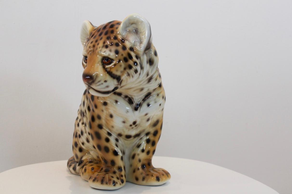 A stunning and rare hand painted porcelain puppy-leopard sculpture made in Italy. This leopard is in excellent condition and marked. With very nice details a true collectors piece.