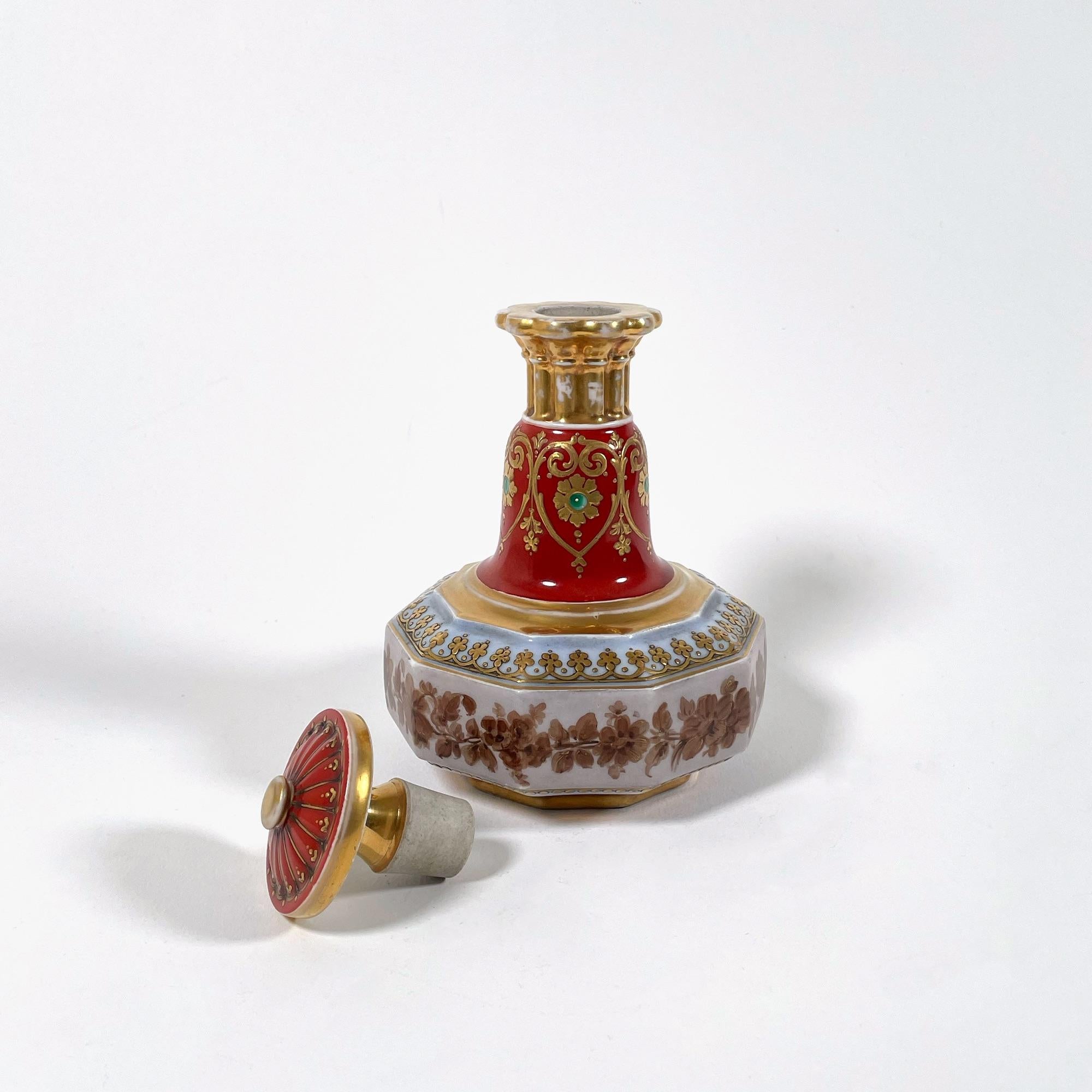 Cette élégante cruche à huile en porcelaine peinte à la main, datant des années 1950, est un superbe exemple de l'artisanat oriental. D'une hauteur de 18 cm et d'un diamètre maximal de 11,5 cm, cette pièce magnifiquement ornée présente une dorure