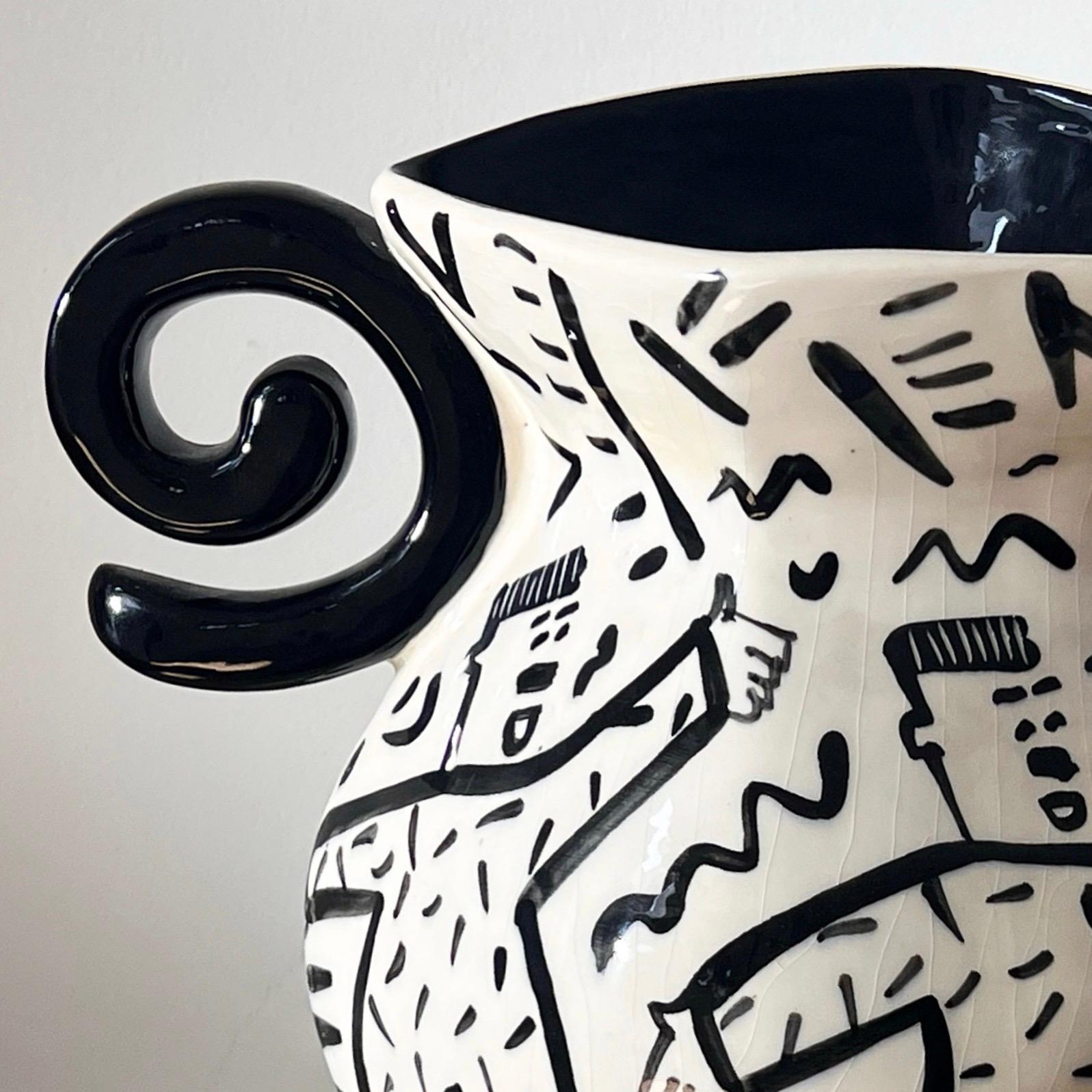 A unique postmodern hand-painted glazed ceramic vase by Australian artist Jiri Bures, late 20th century. Featuring an elaborate geometric shape, molded spiral handles, and an almost Keith Hering esque line drawing motif showcasing squiggles and