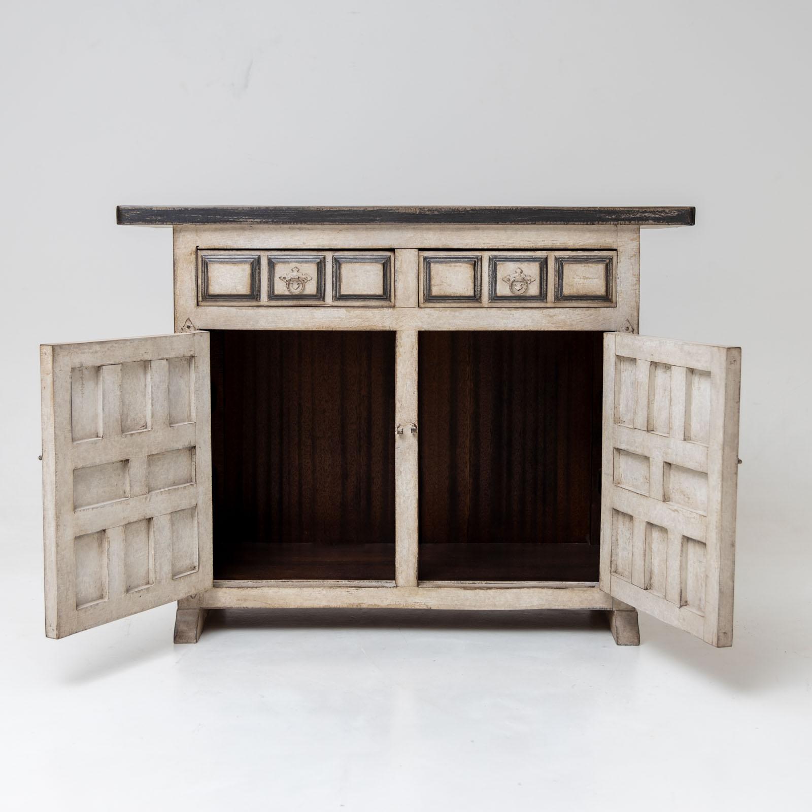 Small painted sideboard with two doors and coffered sides and front. There are two additional drawers above the doors. The creamy white painting with gray accents is new and has an antique patina.