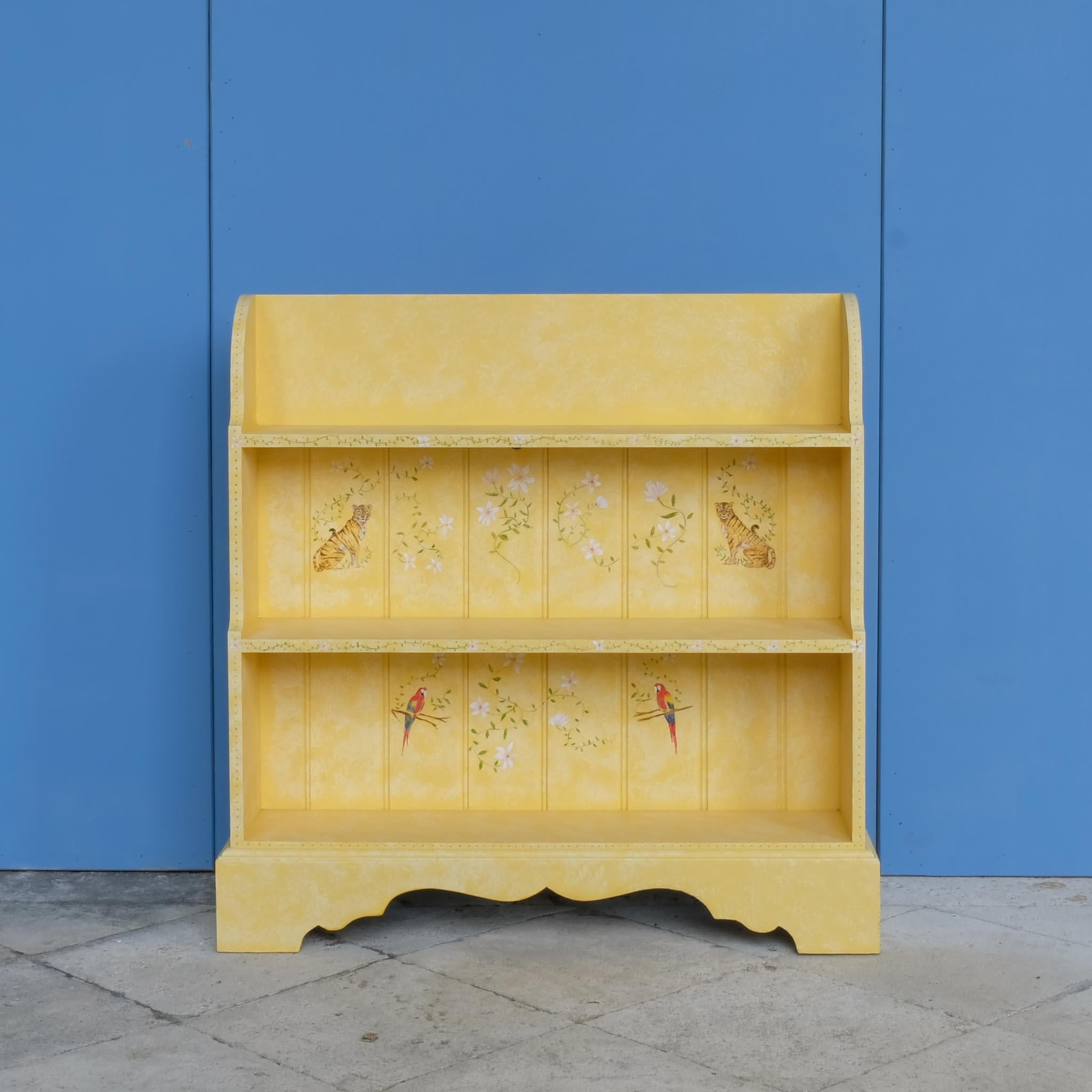 A bookshelf hand painted by decorative artist Bunny Howe, with whimsical safari flora and fauna over a dappled yellow base. In excellent condition. Perfect for a child's bedroom or nursery.