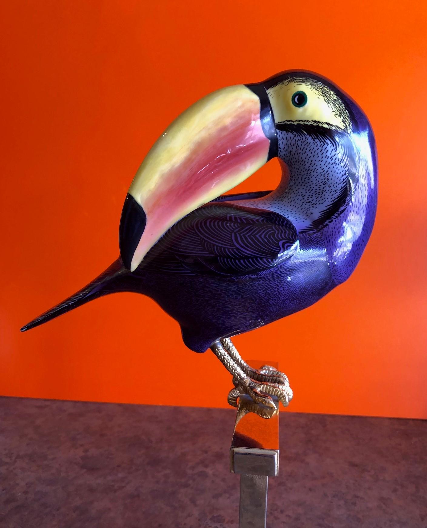 Exceptional hand painted porcelain stylized Toucan designed by Giulia Mangani for Oggetti, circa 1980s. The piece is multicolored with a rich, deep purple background and amazing attention to detail. The legs are gold gilt and the piece sits on a