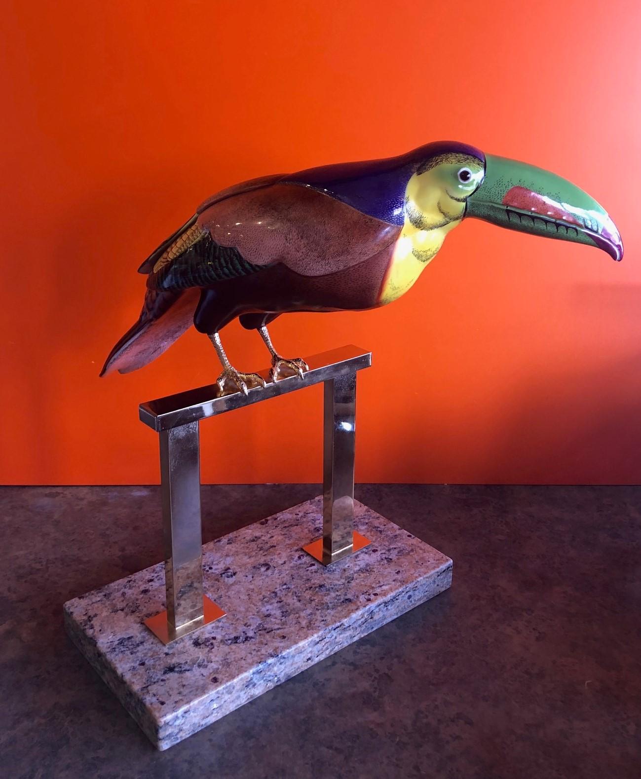 Exceptional hand painted porcelain stylized toucan sculpture designed by Giulia Mangani for Oggetti, circa 1970s. The piece is multicolored with a rich, deep purple background and amazing attention to detail. The legs are gold gilt and the piece
