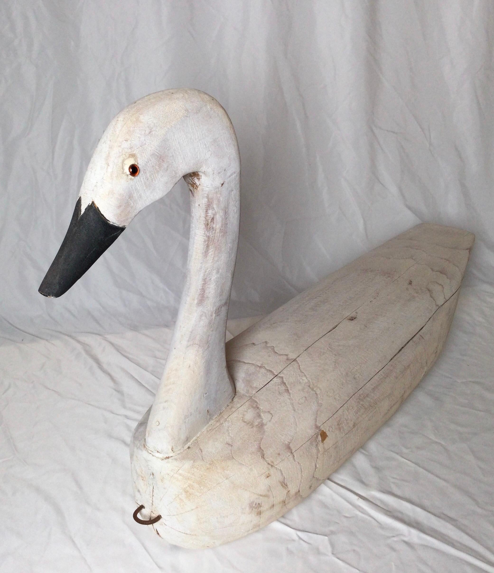 A hand carved and painted wooden swan decoy, artist signed on the base and dated 1988.