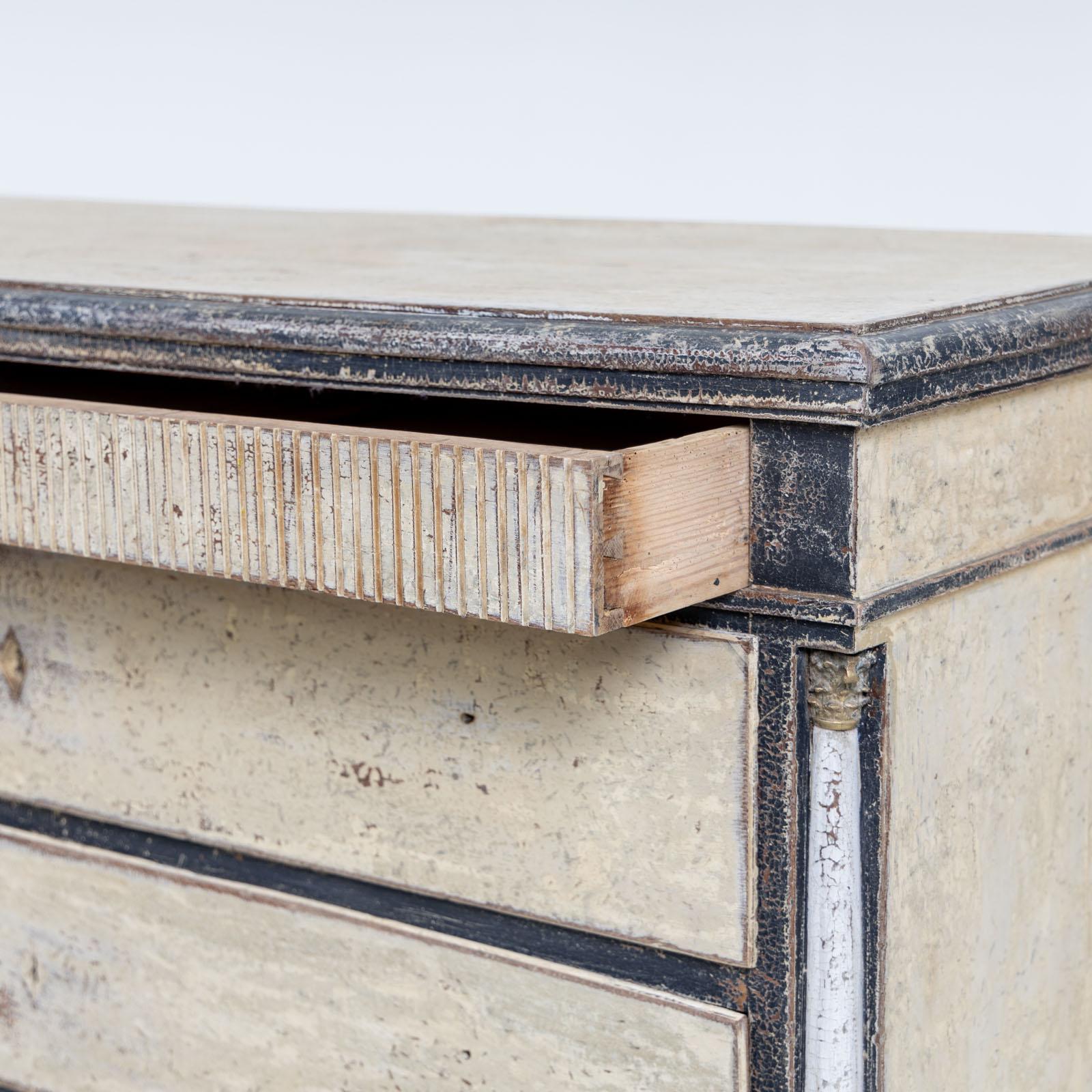 Artfully hand-painted Gustavian high chest featuring five drawers, side columns, and tapered legs. The top drawer is distinguished by a grooved front, adding a touch of elegance. This chest of drawers has undergone a transformation, now showcasing a