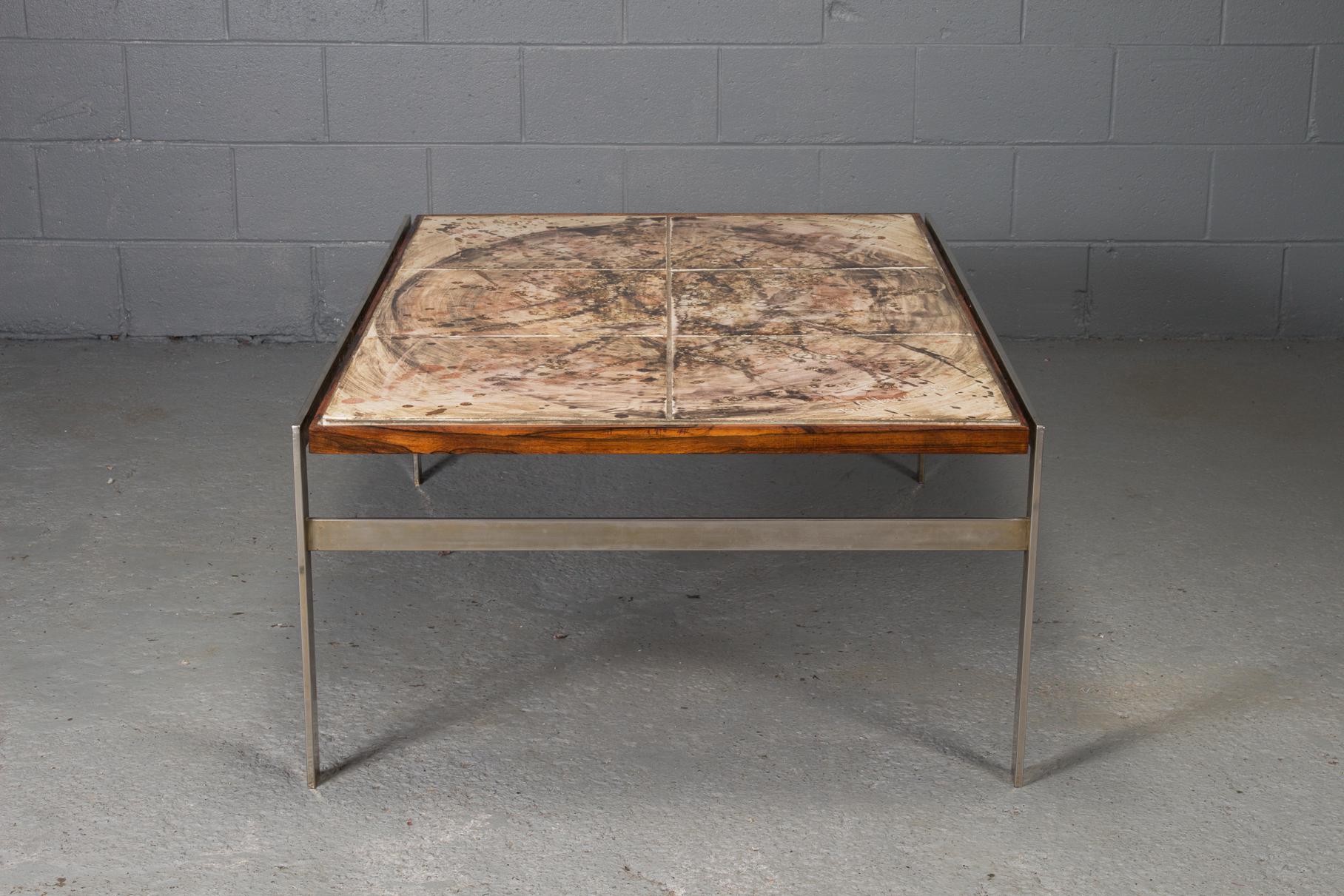 This coffee table is made of hand-painted tile with a rosewood and chrome frame. The piece features a signature indicating it was created in 1973.