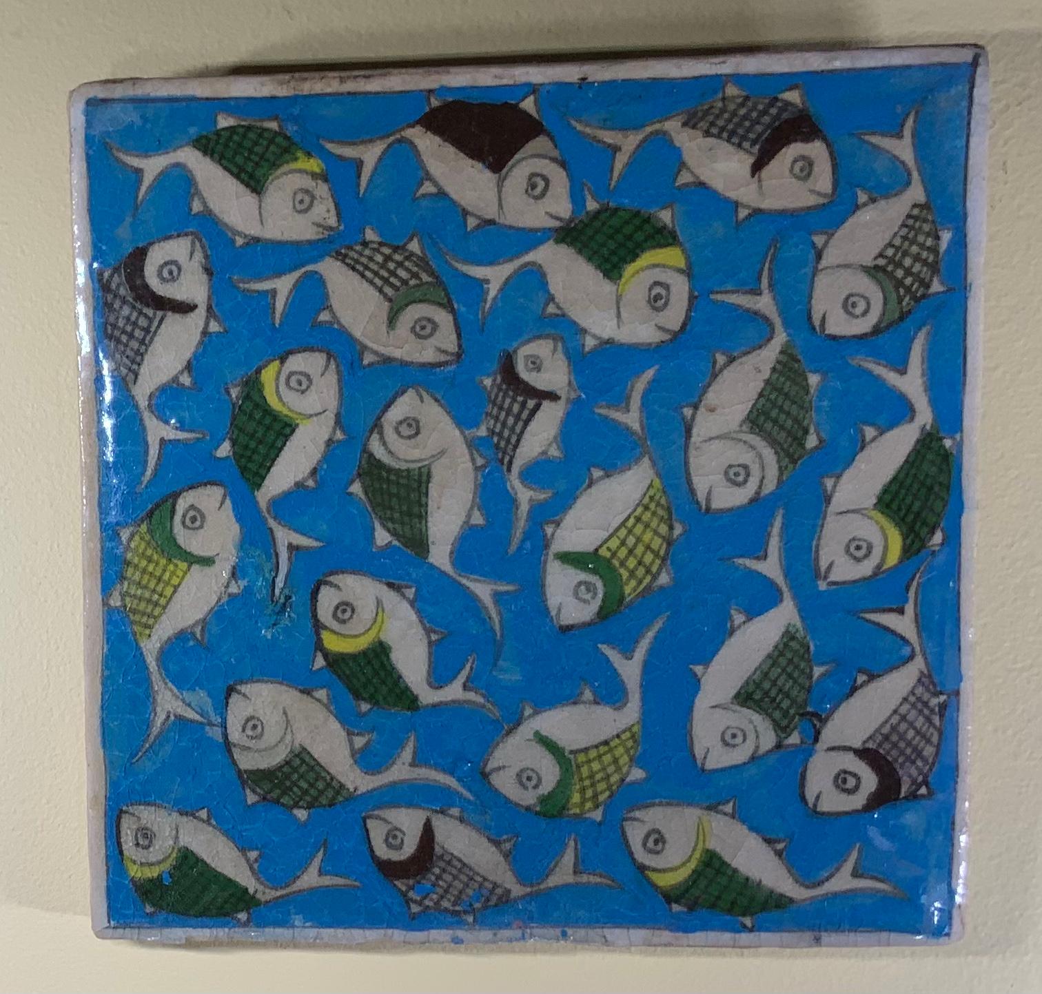 Beautiful ceramic tile hand painted and glazed with exceptional wondering school of colorful fish on a turquoise color background. The tile can hang on the wall.
 