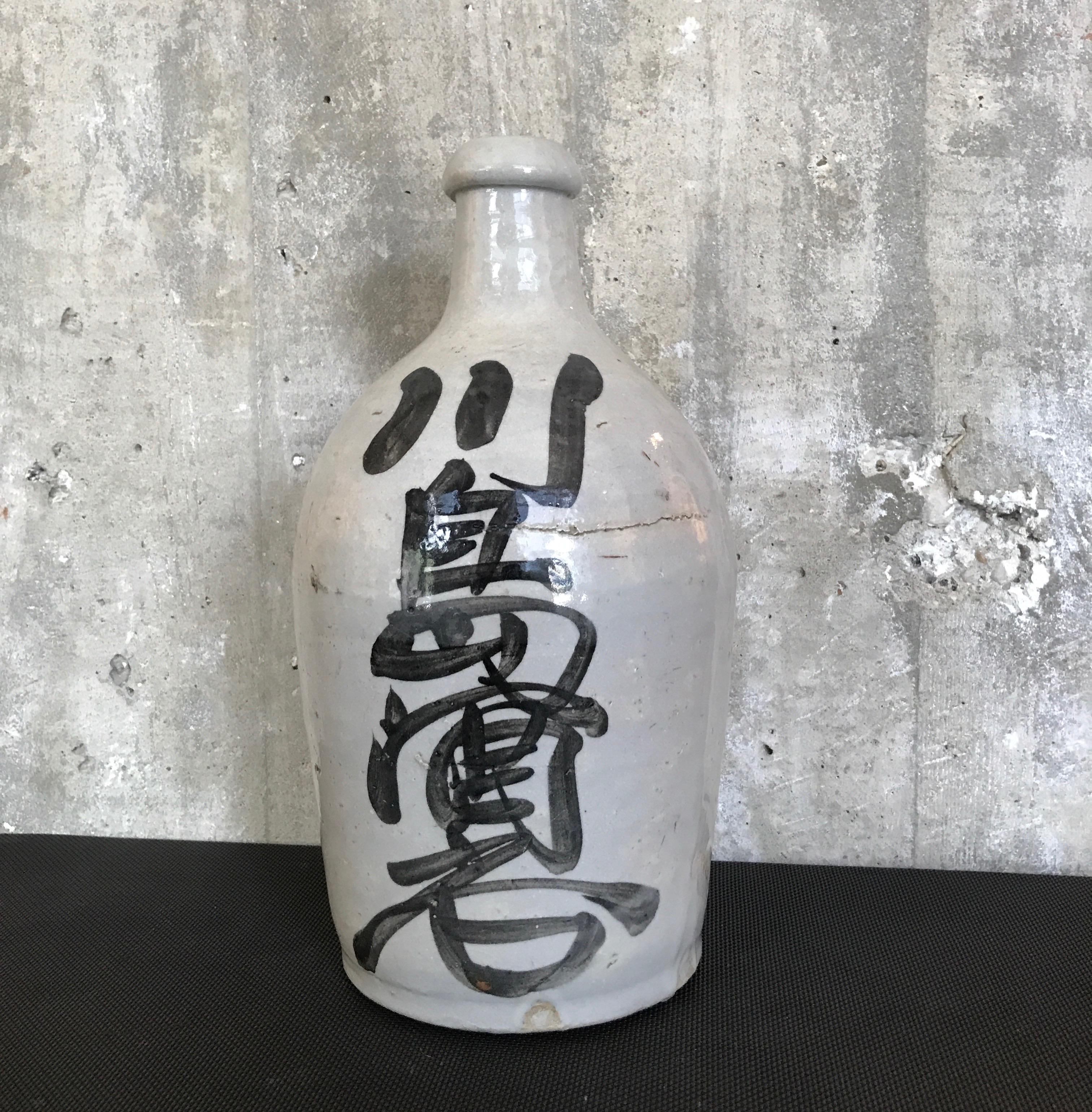 A beautifully glazed and hand painted Japanese sake bottle with gorgeous calligraphy. A wonderful shelf piece. 
Japan, circa 1960.
CR1006.