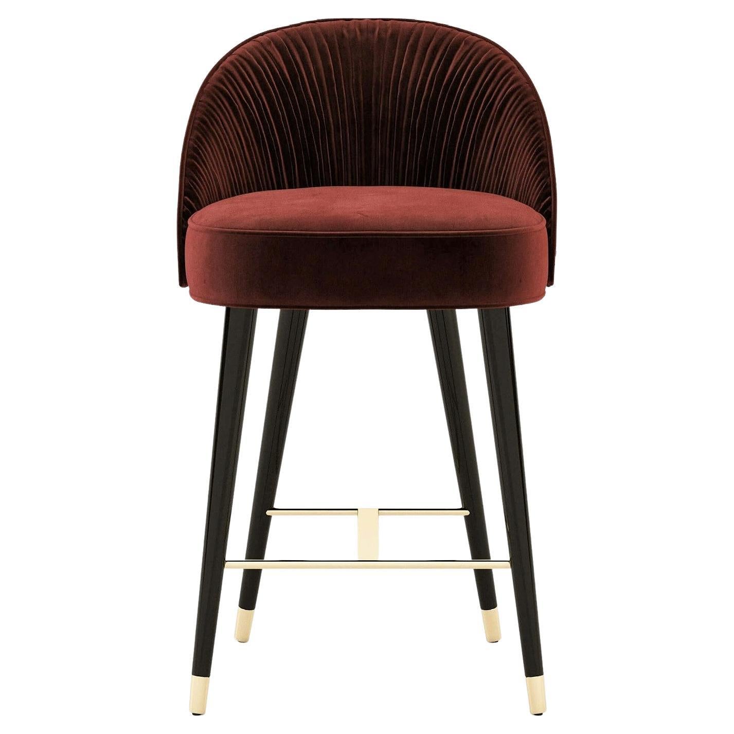 This counter stool holds an elegant combination of handmade couture techniques, wood, and metal, inspired by the unique shapes of worldwide architecture.
Offered in performance velvet in a selection of colors for the upholstery and the piping.