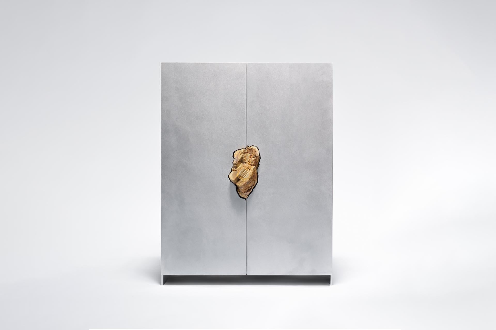 Hand-sculpted cabinet with original petrified oak, Pierre De Valck
Oxidized and waxed aluminium -unique and signed
Measures: 55 x 34 x 70 cm

Small sized cabinet with two hinged doors and four shelves. Mid-cabinet sits a fragment of Petrified