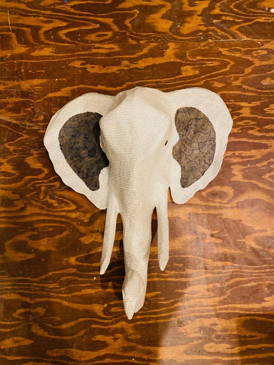 This beautiful papier mâché fake taxidermy sculpture was handmade in the Caribbean. It portrays the head of an elephant in the style of Classic taxidermy. Crafted from recycled materials and finished with prints from Honore’ de Balzac’s 19th century