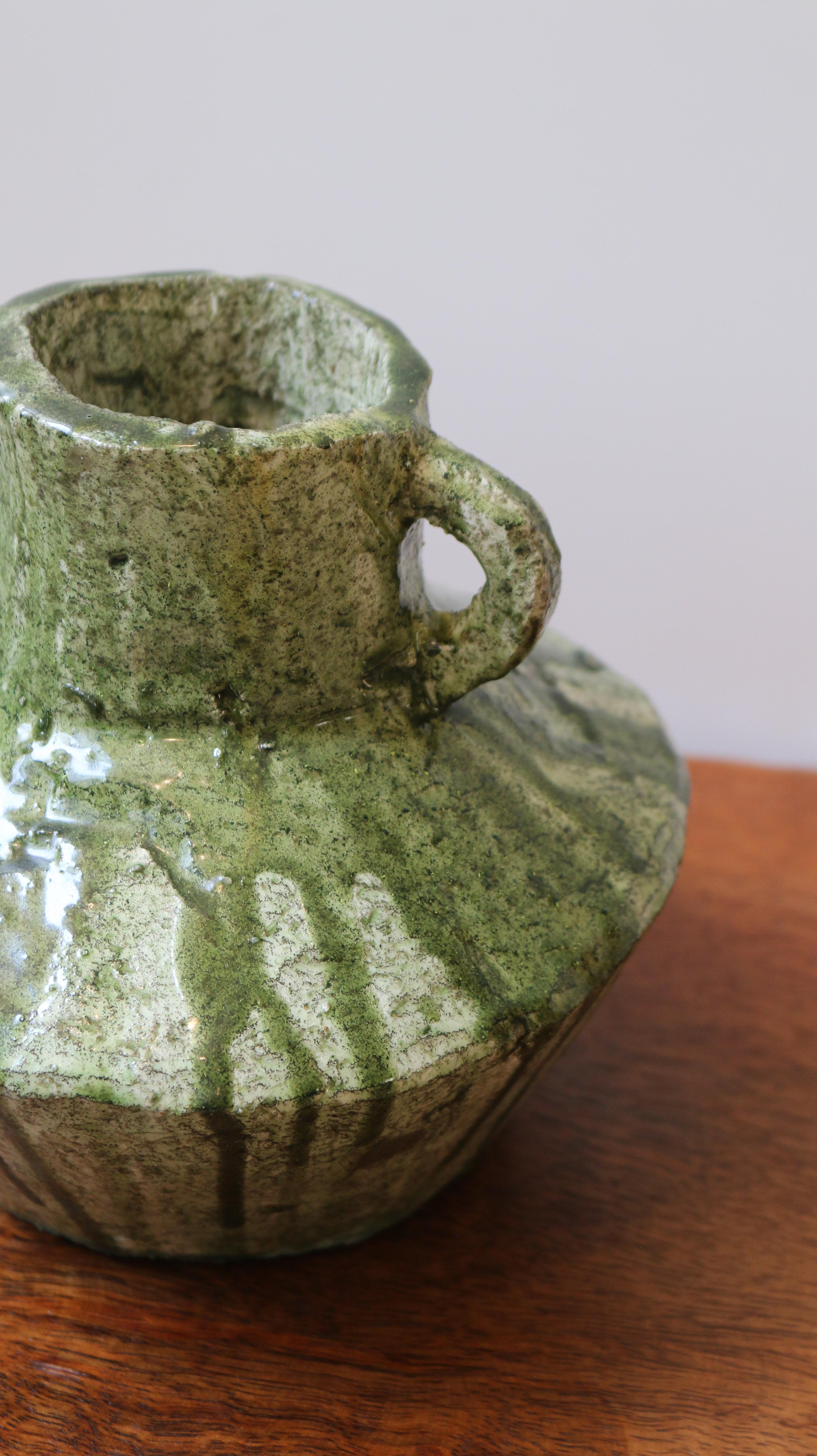 Elaborada en piedra maciza y acabada con un esmalte texturizado aplicado a mano, la Colección Jarrón evoca la serena fuerza de las vasijas antiguas con un espíritu claramente contemporáneo. Cada pieza está esculpida para celebrar la imperfección