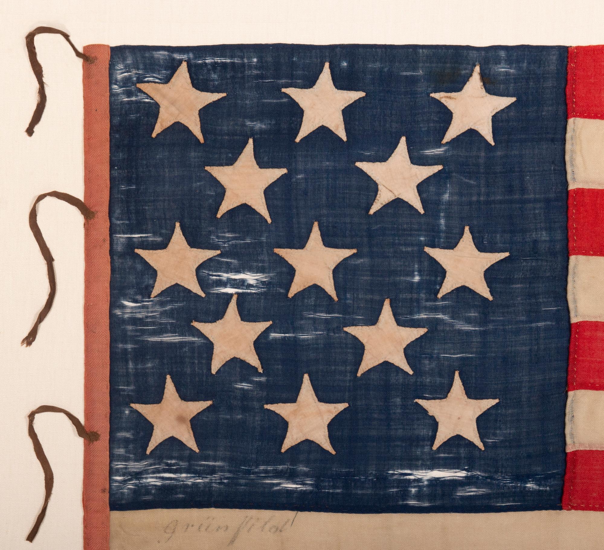 ENTIRELY HAND-SEWN ANTIQUE AMERICAN FLAG OF THE CIVIL WAR ERA, WITH 13 SINGLE-APPLIQUÉD STARS IN A 3-2-3-2-3 CONFIGURATION, IN A GREAT, SMALL SCALE AMONG ITS COUNTERPARTS, PROBABLY MADE IN NEW YORK CITY, SIGNED “GRÜNFILD”

13 star flags have been