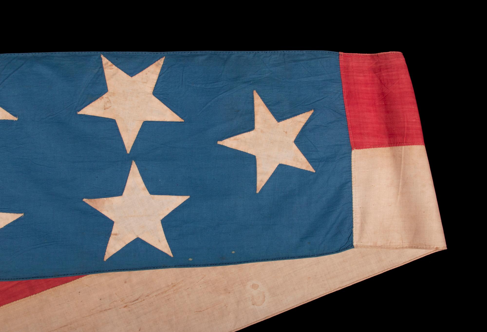 ENTIRELY HAND-SEWN, 32-FOOT, SHIP’S COMMISSION PENNANT OF THE 1845-1865 ERA, A HOMEMADE, COTTON EXAMPLE, WITH 13 STARS ON A CORNFLOWER BLUE CANTON, IN A BEAUTIFUL STATE OF PRESERVATION

Commission pennants are the distinguishing mark of a