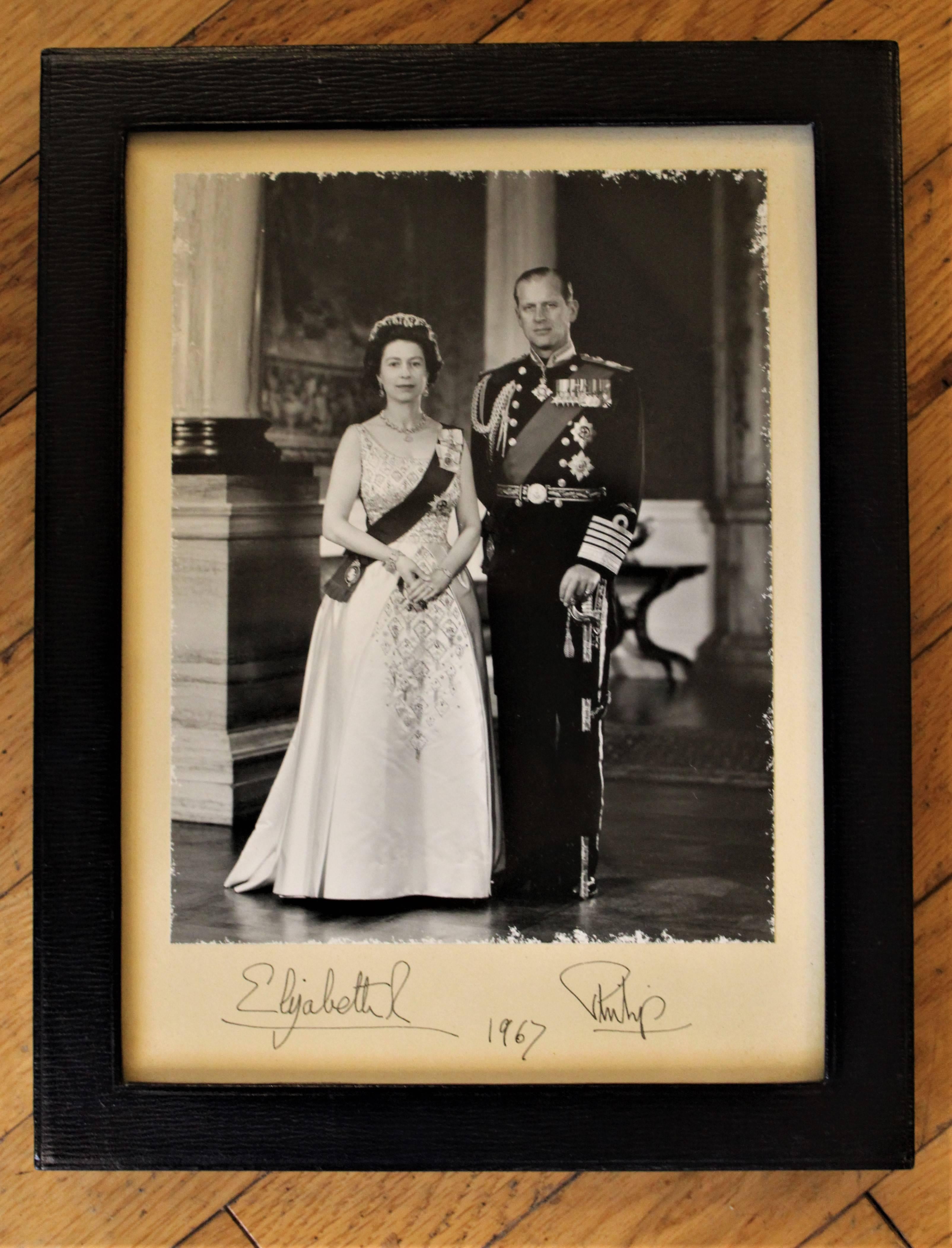 1967 hand signed Queen Elizabeth II and Prince Phillip photograph. In leather frame by Royal framer H.H. Plante London, stamped by Royal photographer Anthony Buckley. Numbered 4929-11.