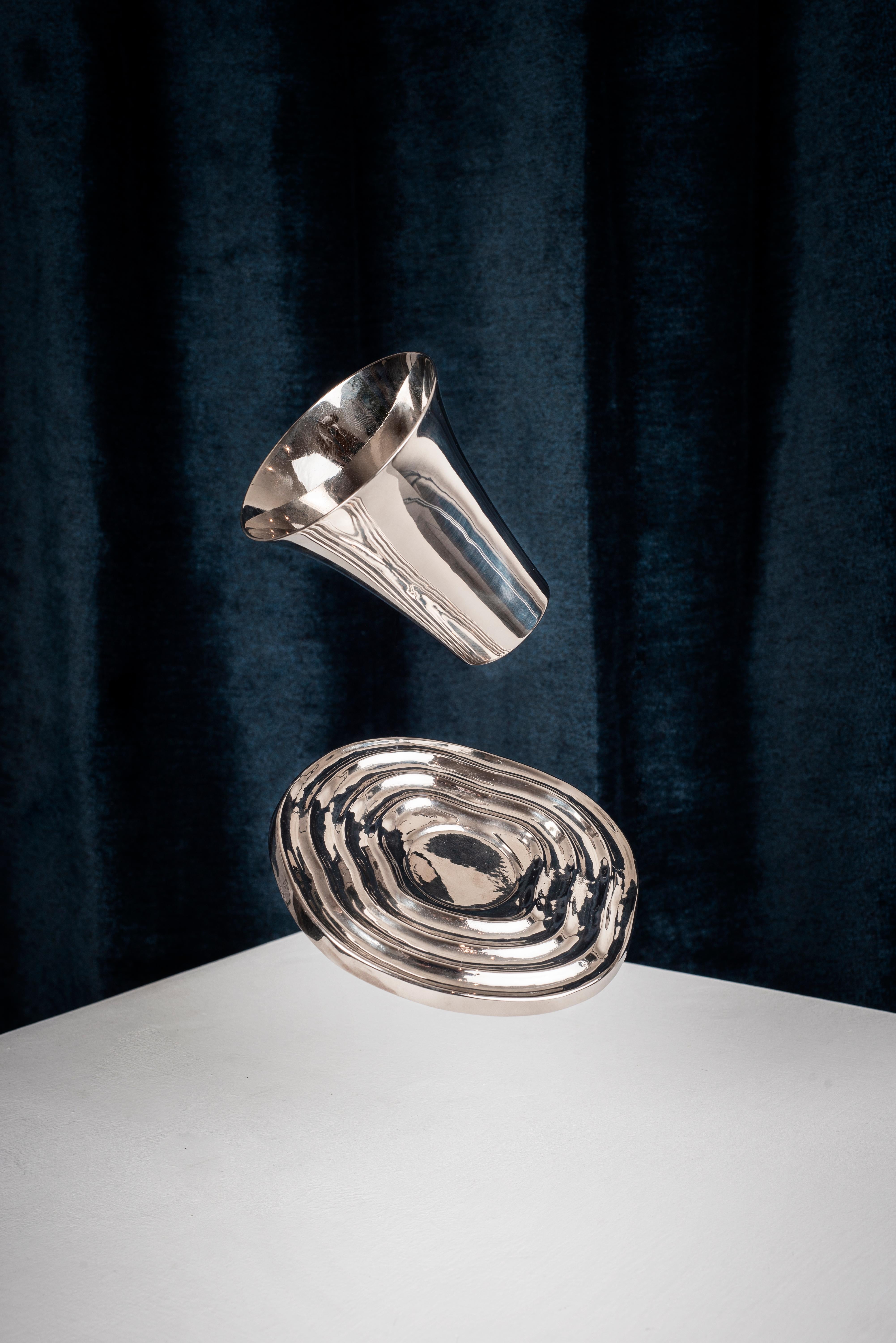 bruci's hand-spun nickel-plated brass overflow cup and saucer takes as inspiration the Shabbat dinner tradition to fill your cup to the brim and spoil some wine, with the hope of having an upcoming week where blessings overflow. The Overflow cup and