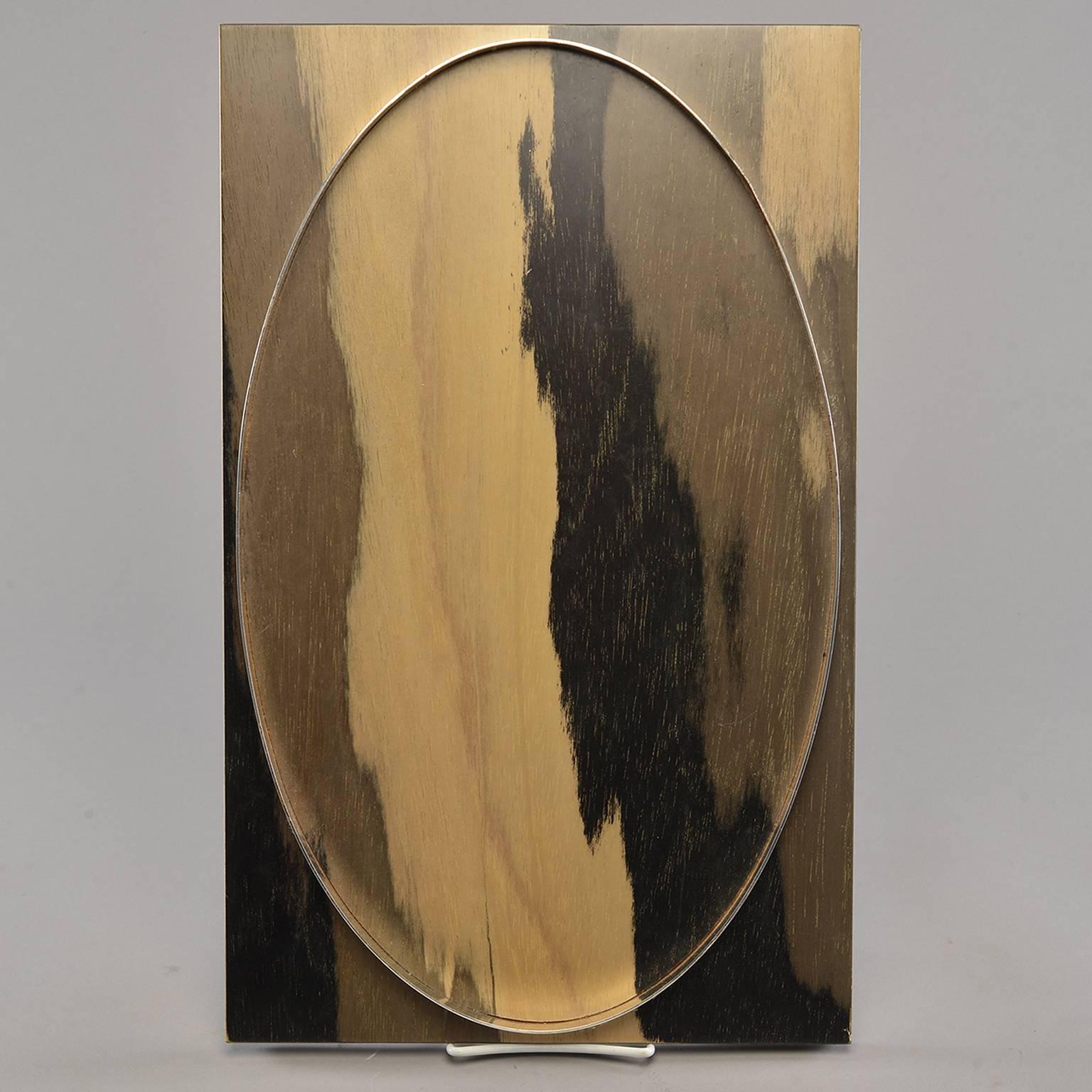 Wood tray found in Italy features rectangular hand stained wood tray in contrasting tones of gold, taupe and black with raised, silver tone metal insert and footed base, circa 1990s. Two available at time of this posting.