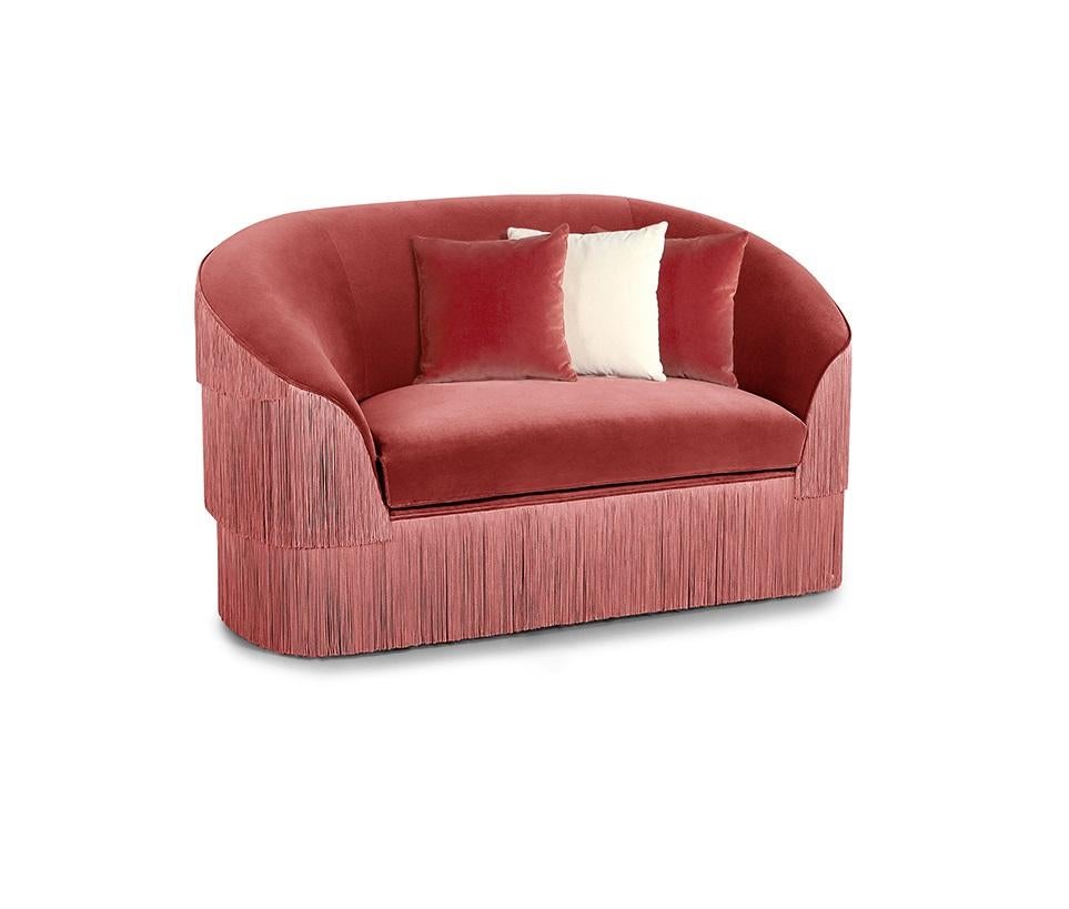 The handmade sofa draws on the signature Franjas fashion theme, ruffling the scene and inviting guests with its fun and flirtatious feel. Featuring three layers of fringes that run along the front and reverse of the wide seat, set against a curved