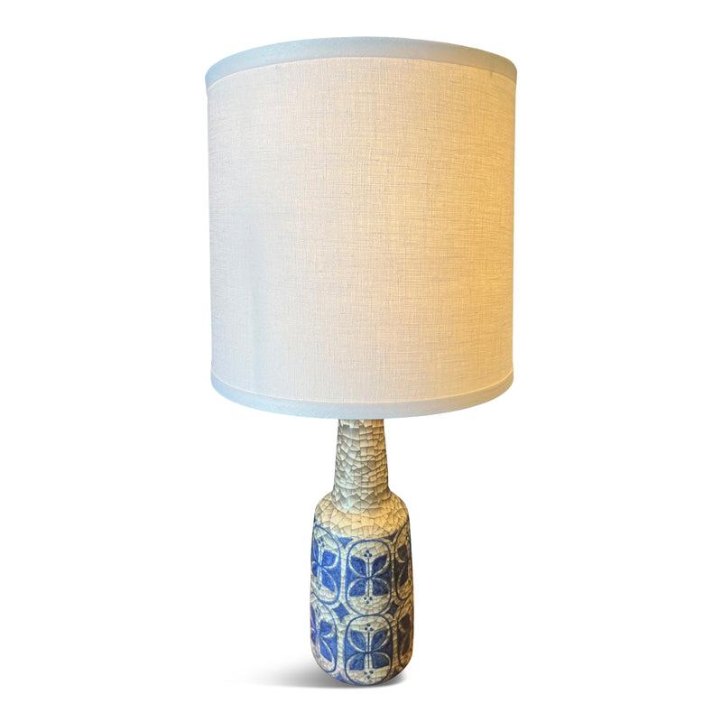 Made in Denmark in the Mid-20th Century, this stoneware ceramic table lamp features intricate dark gray crackle glaze and hand-painted cobalt blue floral folk patterns. Including original Michael Andersen & Son maker's mark.