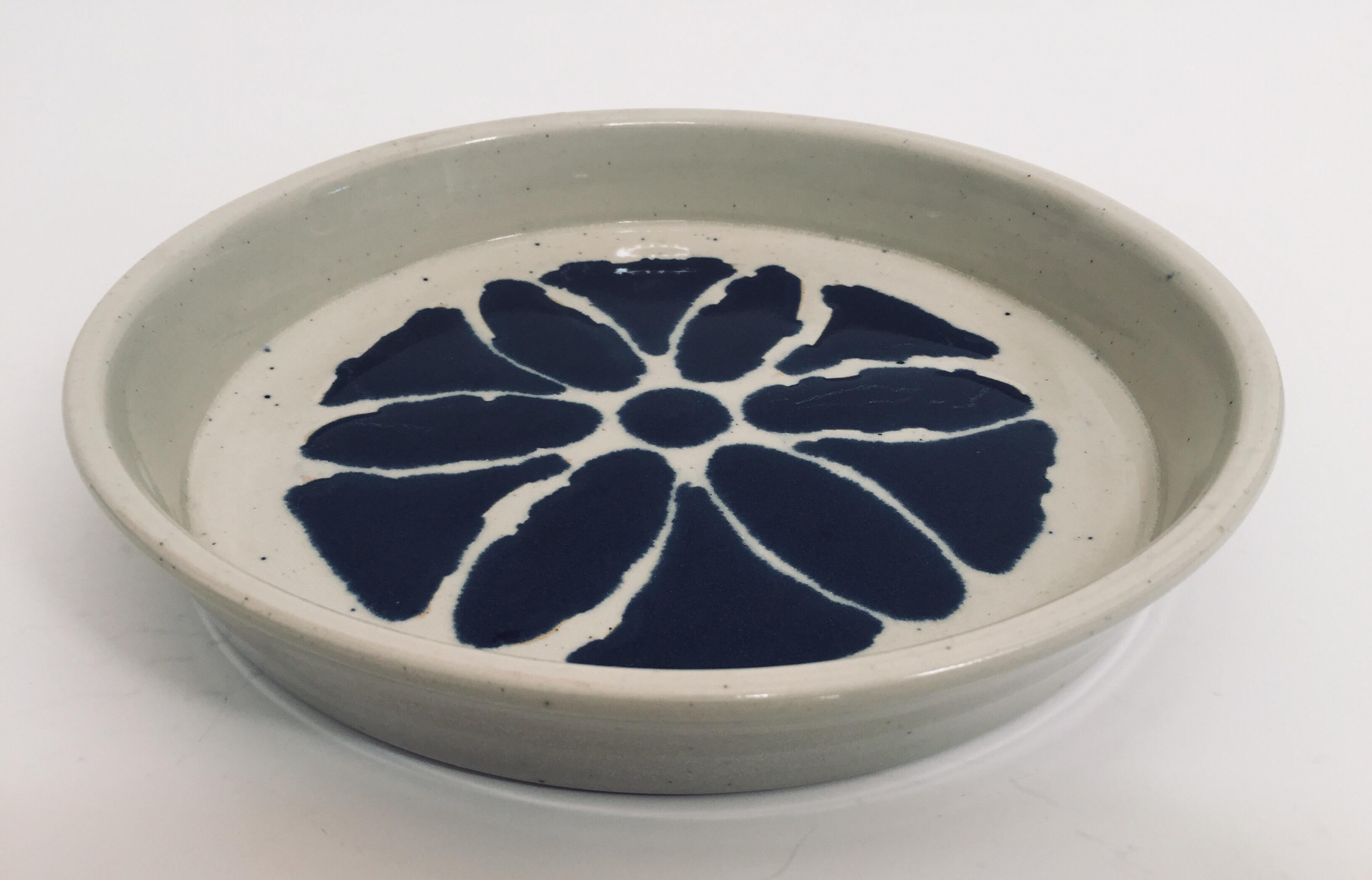 Wheel thrown pottery glazed with a white glaze decorated with a hand painted blue flower pattern.
This is a one of a kind object made in the ancient way by hand in a small artisanal pottery by Christy Johnson. 
Made by hand in Los Angeles,