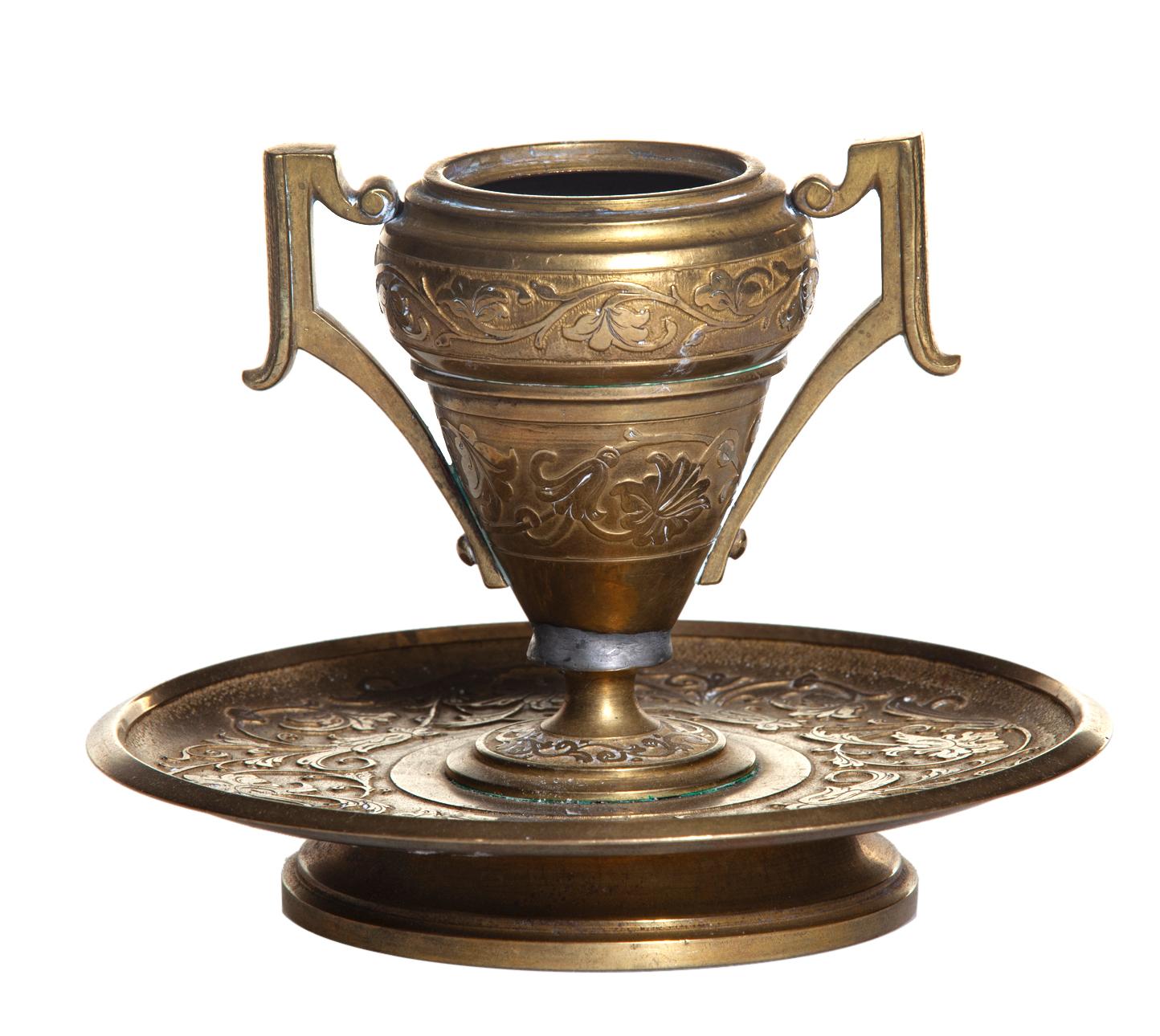 Vintage solid brass hand tooled single candleholder with two handles, sits on a footed round base.