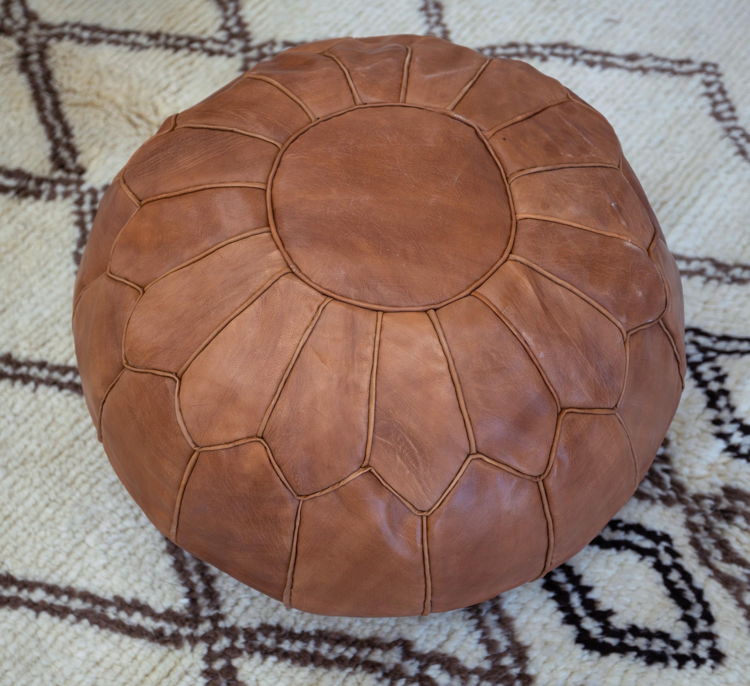 Apportez une touche de charme marocain à votre intérieur avec ce pouf exquis en cuir marron travaillé à la main. Fabriqué par des artisans qualifiés à partir de 100 % de cuir véritable, ce pouf met en valeur le savoir-faire traditionnel marocain,