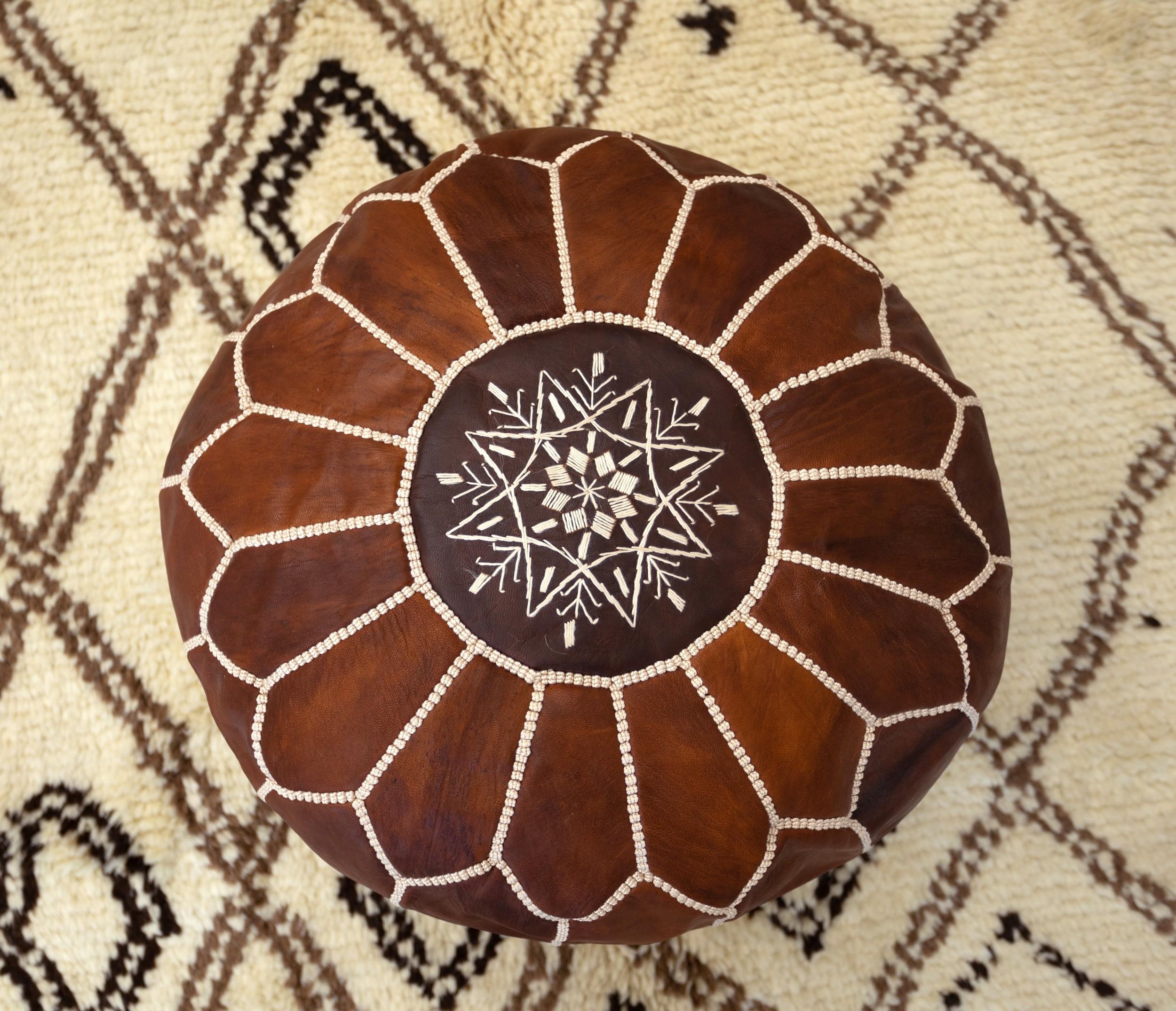 Dai un tocco di charme marocchino alla tua casa con questo pouf in pelle marrone lavorato a mano. Realizzato da abili artigiani con il 100% di vera pelle, questo pouf mostra la tradizionale lavorazione marocchina, con intricate cuciture a mano e