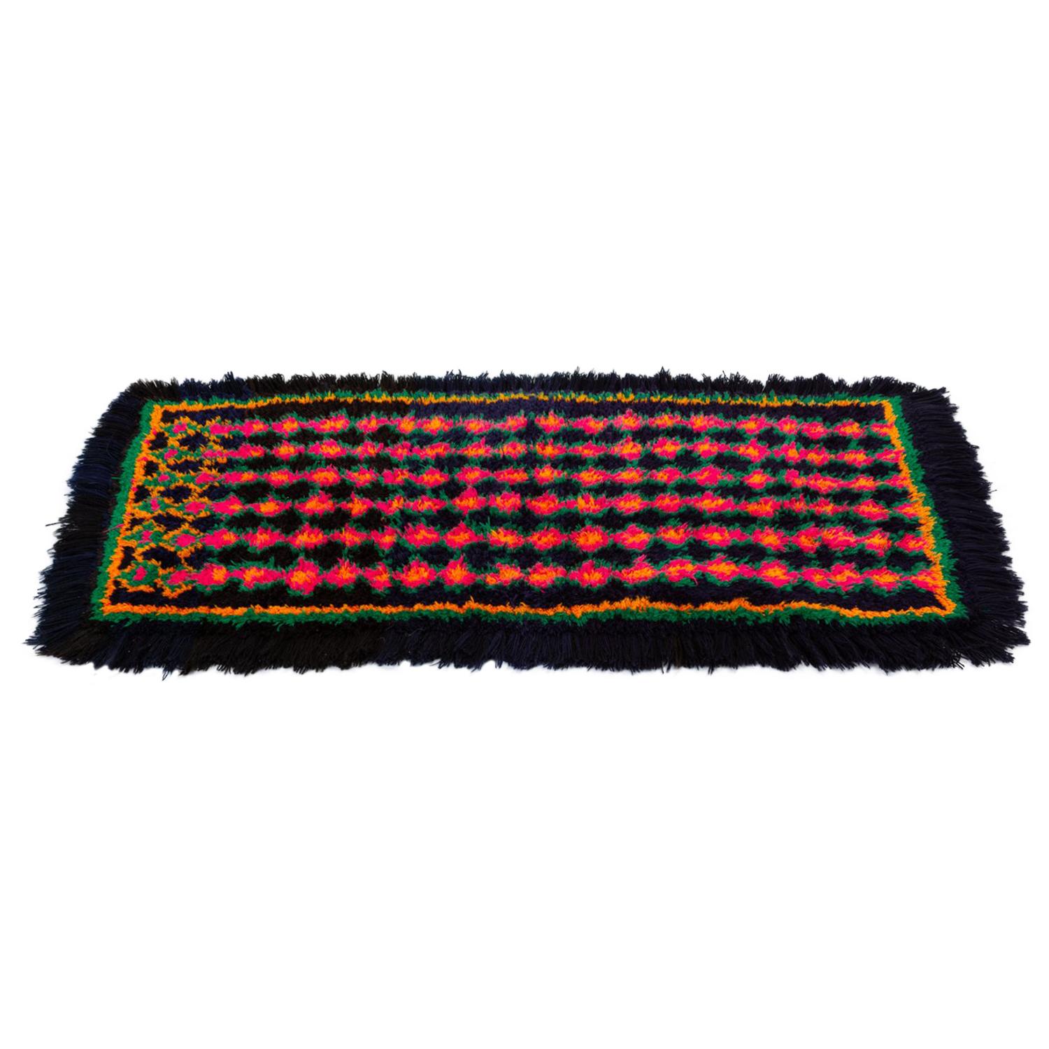 A small rectangular woven textile in bright colors from Peru would make an ideal runner for small spaces, or soft floor mat. The rug has a hand-woven base that lays out a garland pattern in muted tones provides a layer of support underneath the