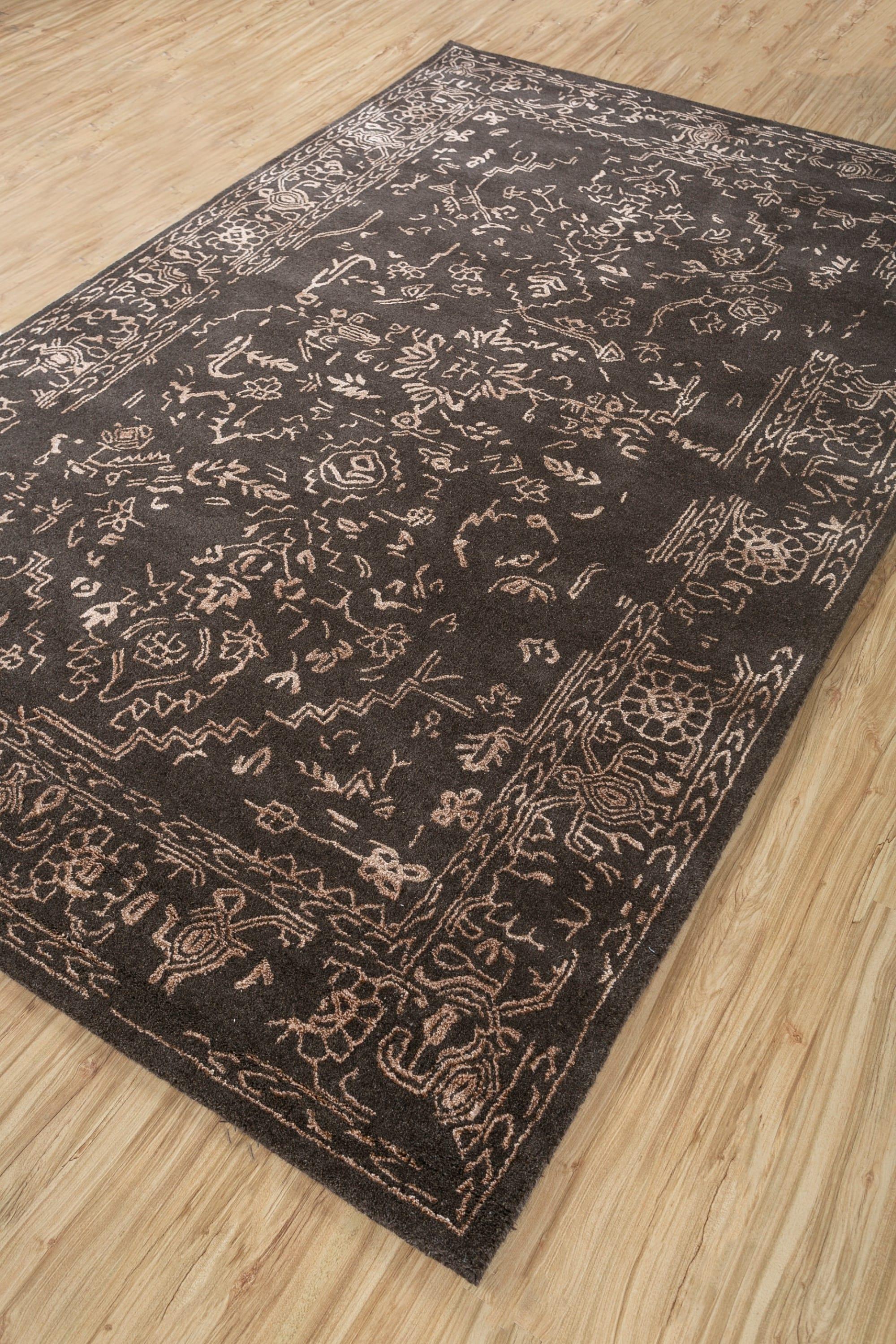 Ce tapis 5' x 8' tufté à la main de Jaipur Rugs présente une riche palette de brun foncé et d'abricot, créant une atmosphère chaleureuse et invitante. Fabriqué à partir de fils de laine et de viscose de qualité supérieure, le tapis arbore un design