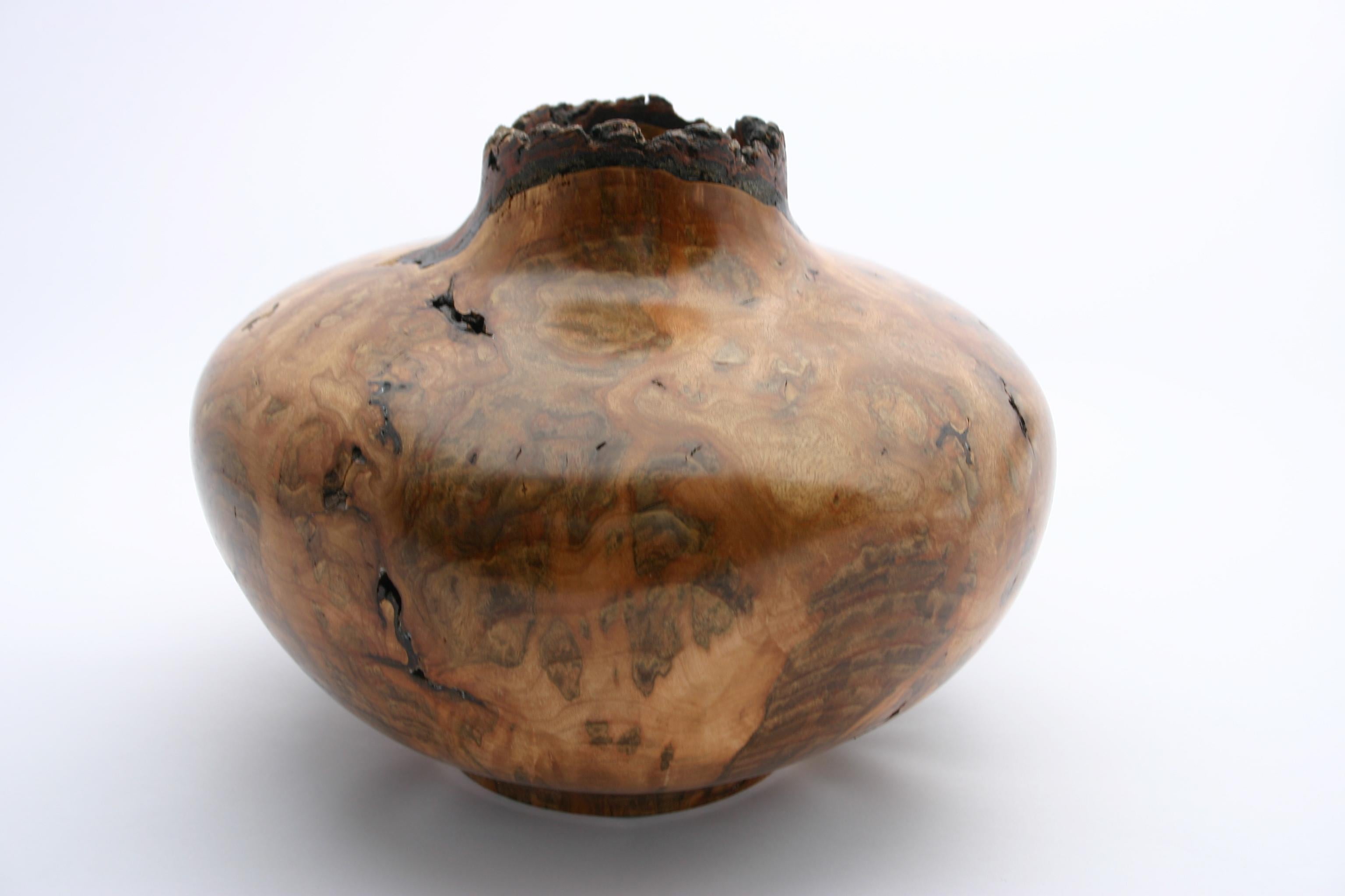 Hand-turned maple burl wood finished to perfection with a natural edge. These pieces are generally carved from freshly cut trees in such a way that the tree’s bark is still attached to the rim. Artist James Krom.