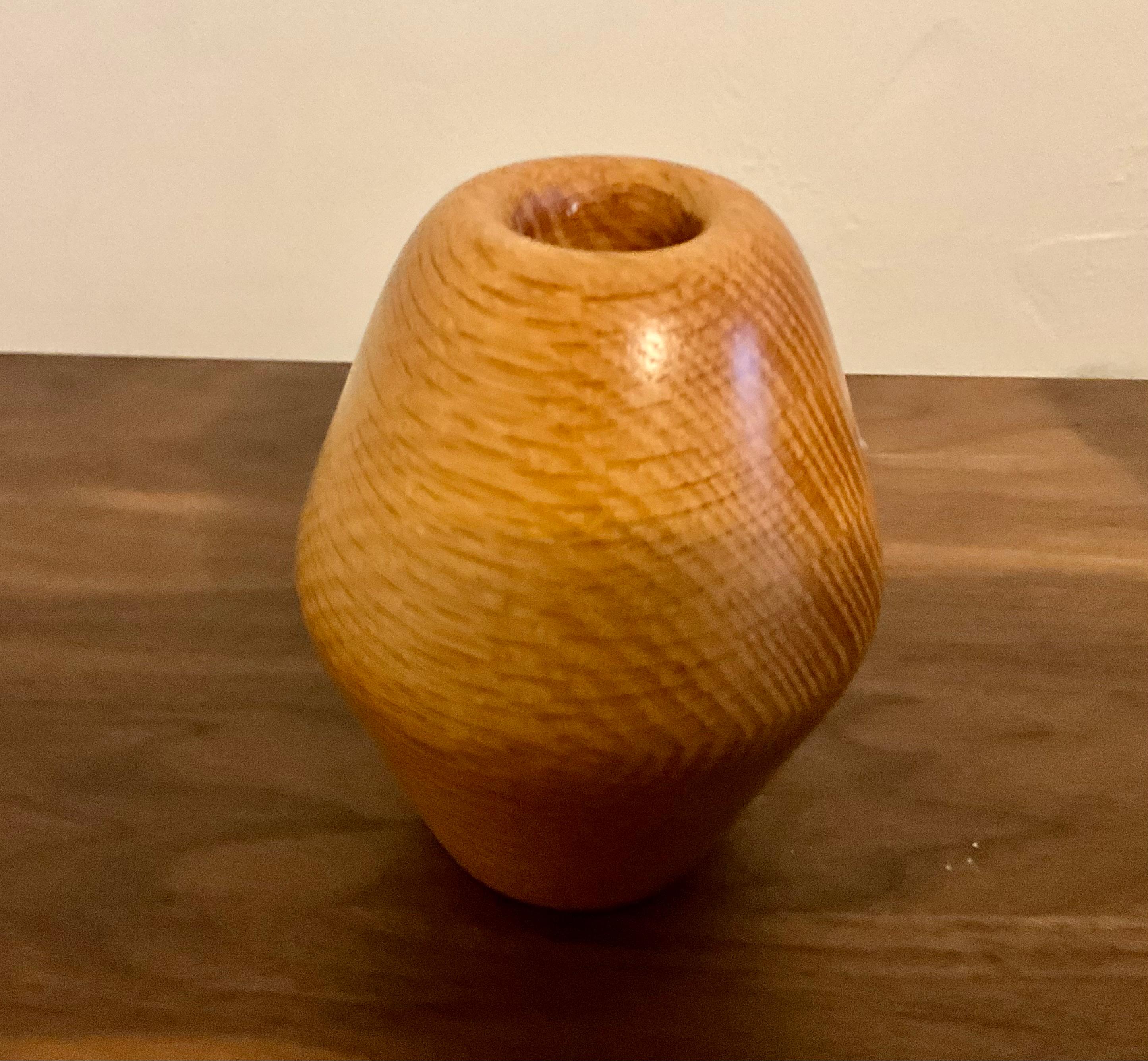 Hand-Turned Studio Vase by L. Cheney  
This beautiful hand-turned studio vase, standing at 5.5 inches tall, is a captivating piece by artist L. Cheney. Crafted from high-quality wood, it features a striking grain pattern that adds depth and
