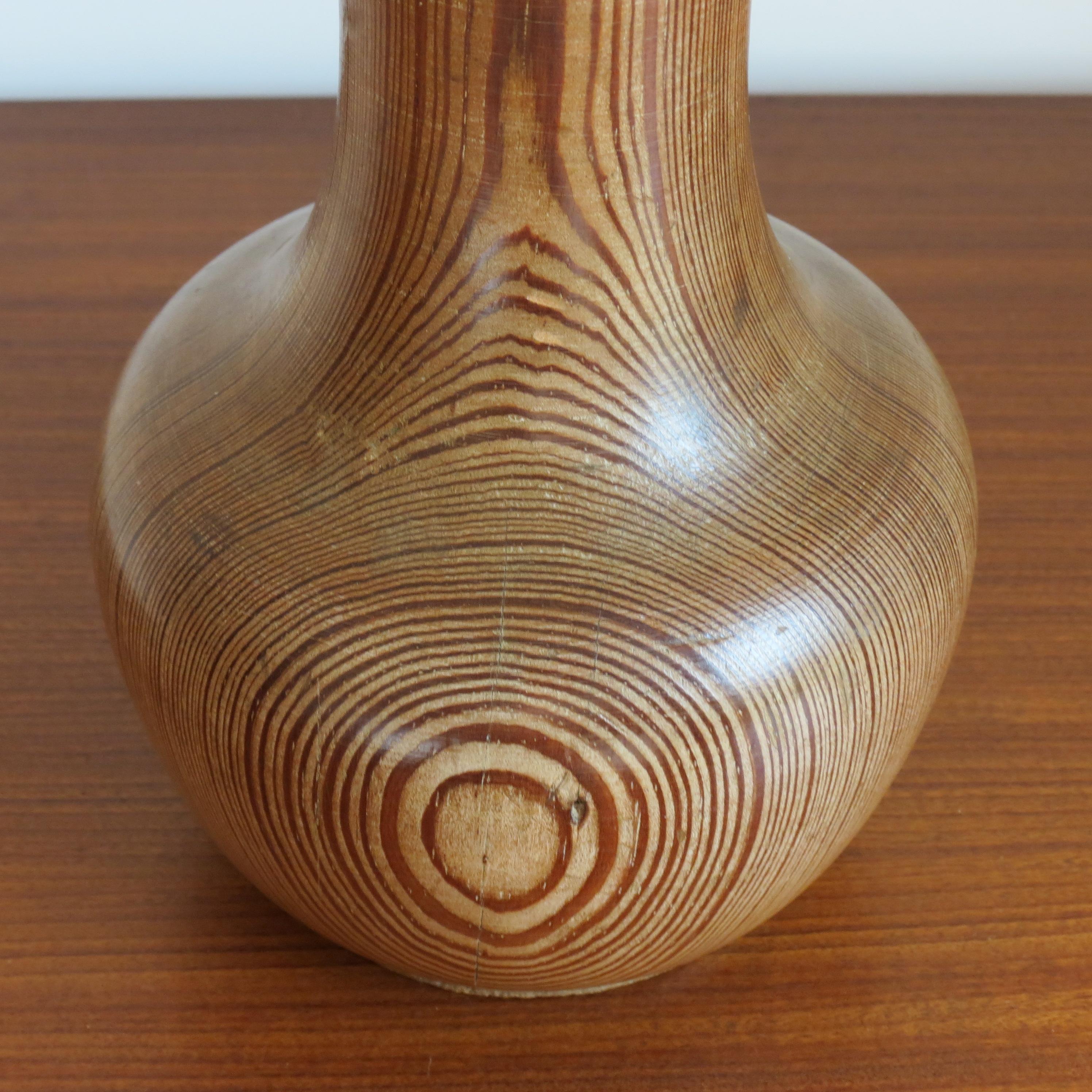 Handgedrehte Skulptur aus Kiefernholz in Vasenform. Die Form der Skulptur aus antiker Pitch Pine zeigt die wunderbare Maserung des Kiefernholzes. Sehr geschickt gedreht, die Vertiefung zum Hals der Vase befindet sich auf halber Höhe des Stücks, der