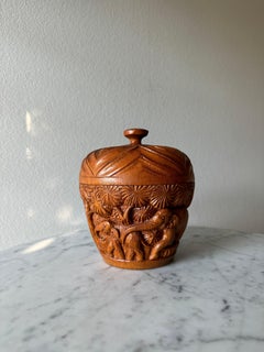 Handgeschnitztes Holzgefäß mit Deckel.