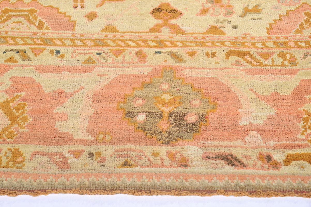 Neutral and orange toned antique Turkish Oushak rug handmade in ancient Turkey during the later half of the 19th century. The authentic vintage piece is made of wool and the pile weave construction method, and features floral and Traditional design
