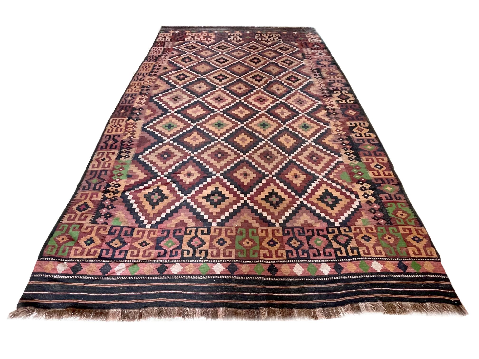 This rug is an Afghan Rug which is a workshop carpet woven by a weaving house in Afghanistan. Afghanistan has a rich history in the Craft of rug-making. The design in this piece is tribal allover diamond design. The color combination in this piece