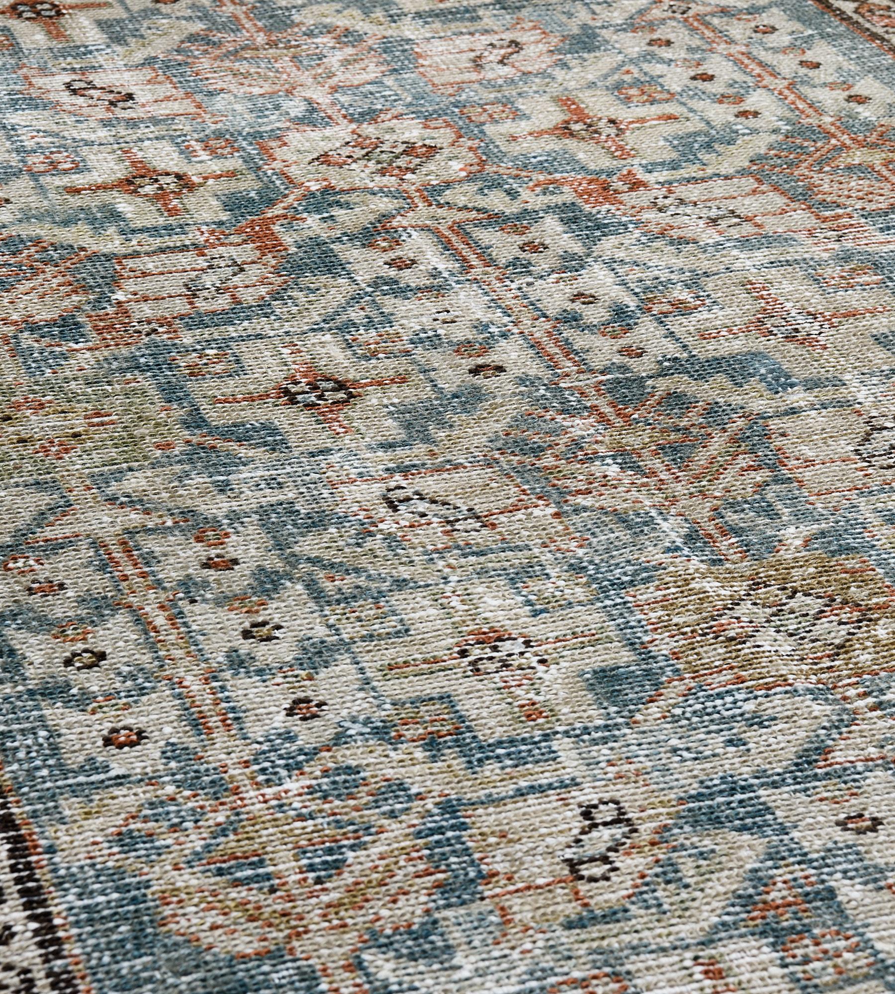 This antique Malayer runner has a sea-blue field with a dense ivory, fox-brown and pistachio-green angular linked lozenge and serrated leaf vine, the ivory spandrels with stellar flowerheads, in a narrow buff-brown floral vine border between light
