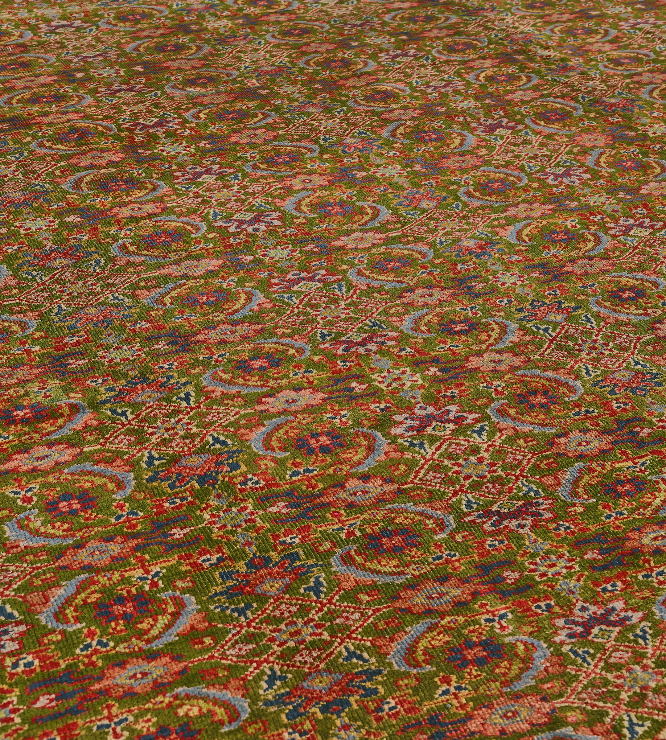 Ce tapis traditionnel persan Sultanabad tissé à la main présente un champ chartreuse chaud avec un motif herati général, dans une bordure de palmettes de tortue entrelacées rouge rubis, entre une profusion de lianes florales polychromes et de