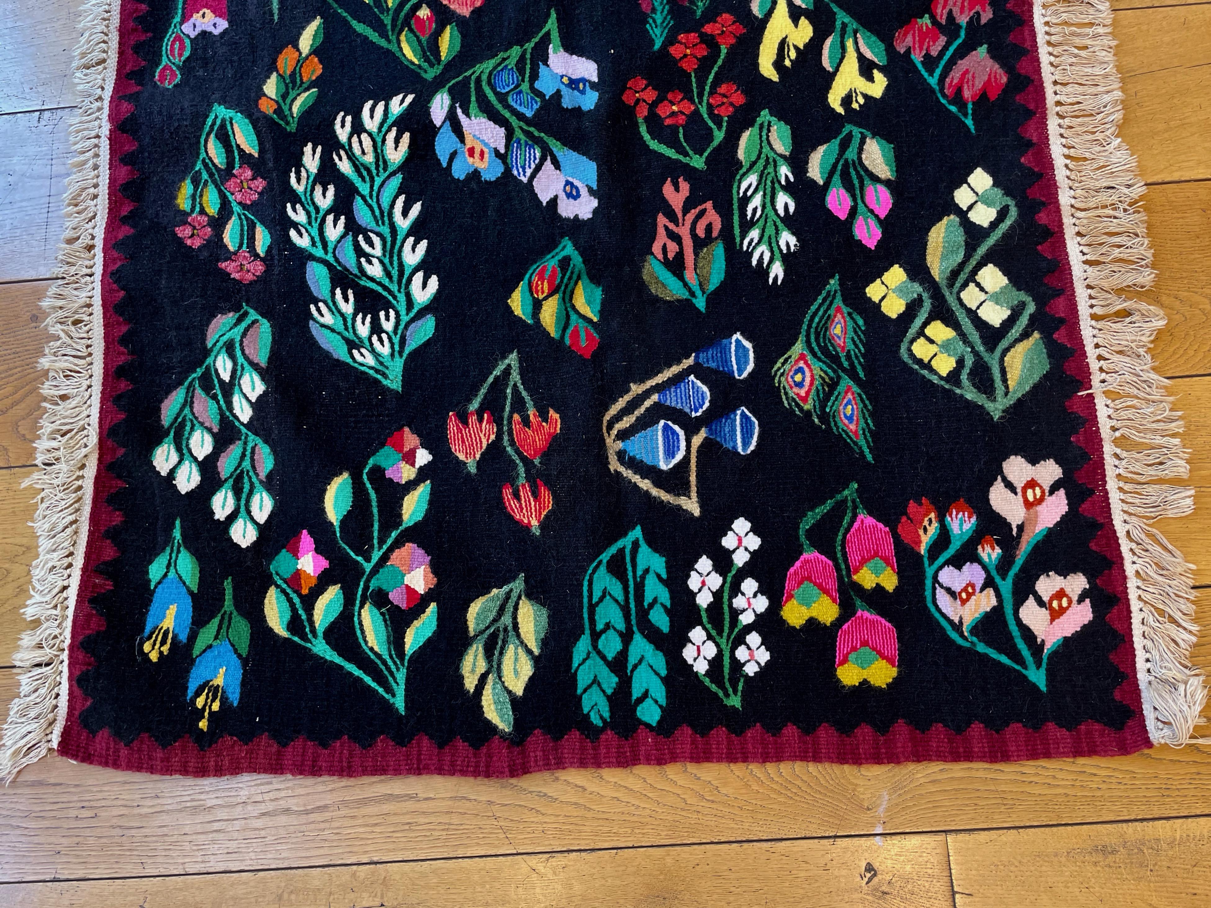A beautiful hand woven wool kelim rug . Woven in to the black wool  background are stylised variations of plants in bright colours.Produced in Beserarabia, in south-eastern Europe on the Black sea, about 1940.
The rug is in very fine condition.
