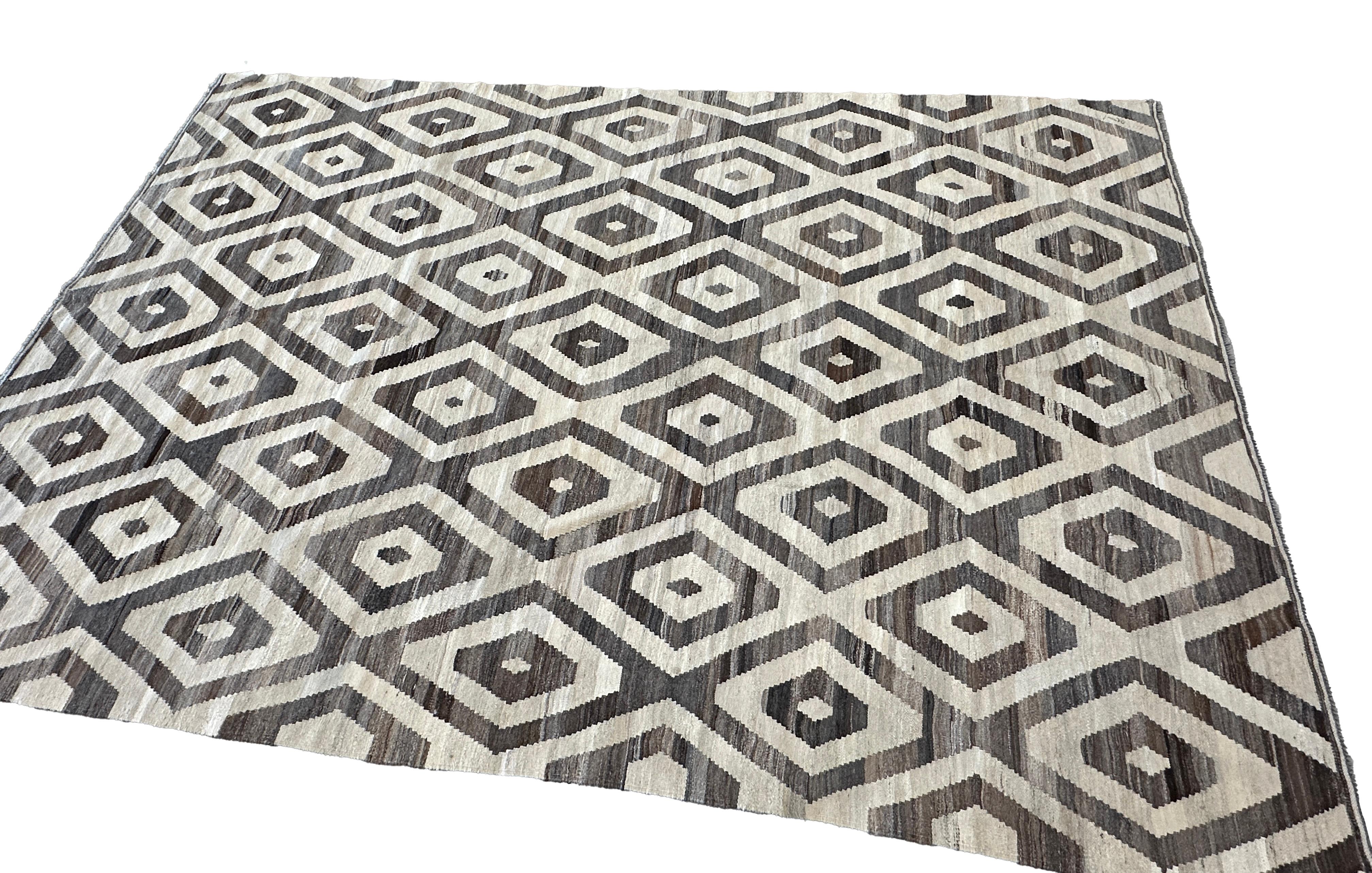 Enhance your home decor with this stunning flat weave kilim rug, featuring a bold brown and cream diamond pattern. Hand-woven by skilled artisans, this rug combines traditional craftsmanship with contemporary design, creating a statement piece that
