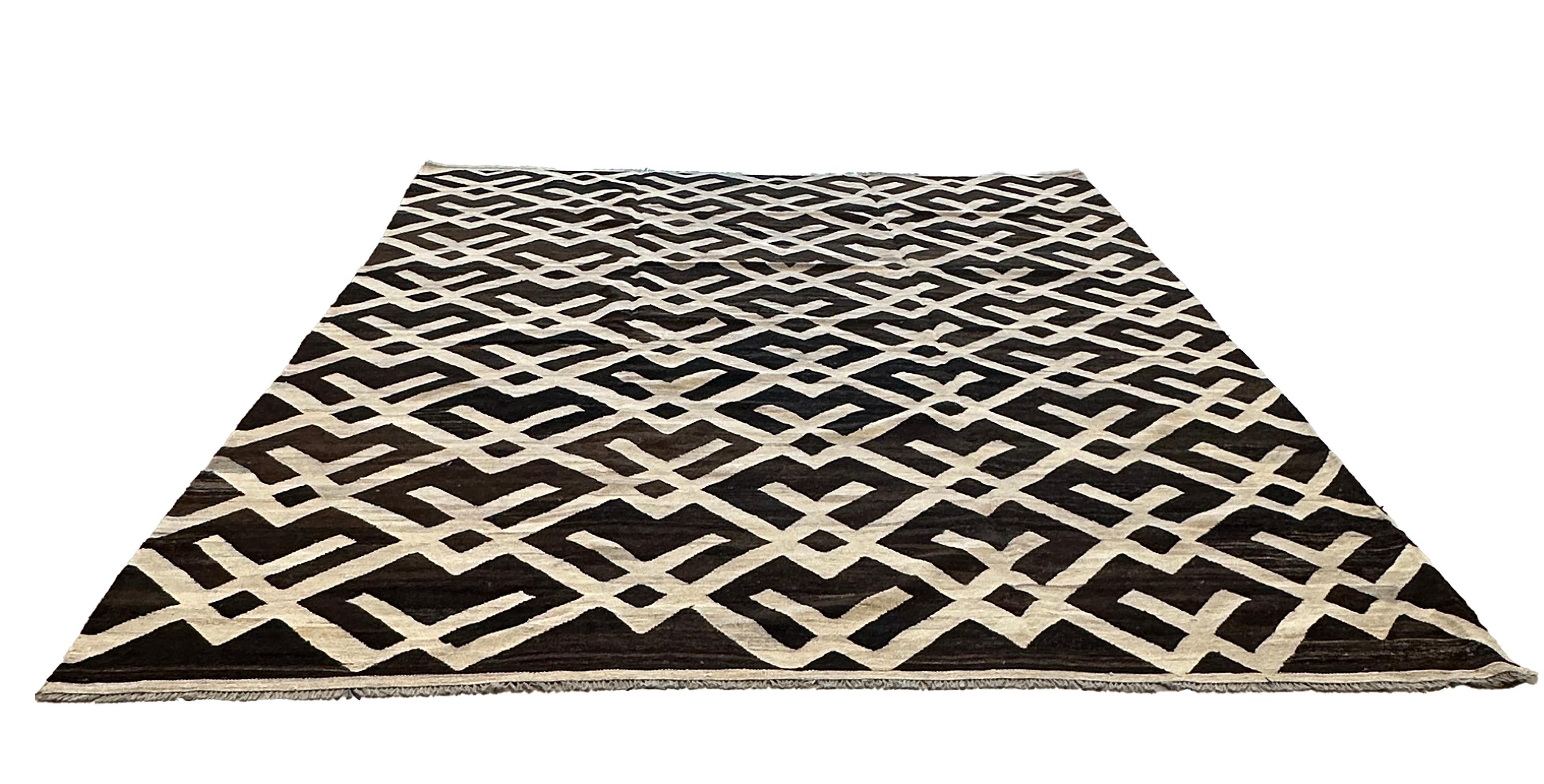 Transform your space with this beautifully hand-woven flat weave kilim rug, featuring an elegant brown and cream pattern. This rug is a perfect fusion of traditional craftsmanship and modern aesthetics, making it a versatile addition to any home.