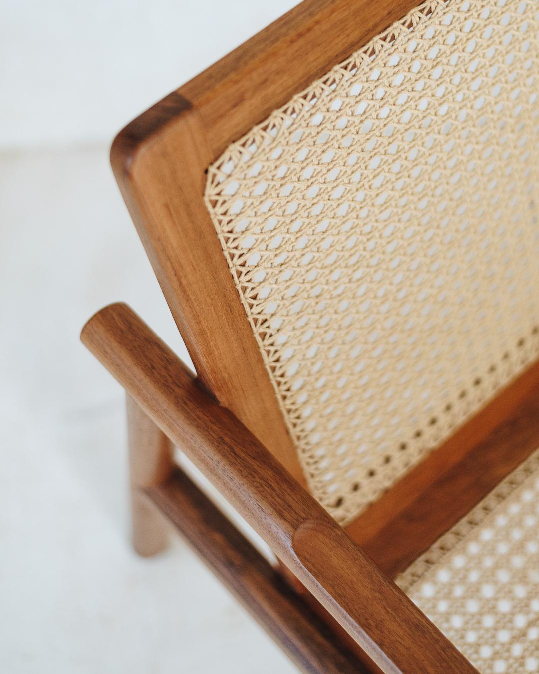 Le fauteuil a une structure simple et très légère. Ses lignes épurées, aux bords lisses et arrondis, s'harmonisent avec le motif méticuleusement tissé à la main. Dans ce tissu tissé à la main par une famille d'artisans de Bacalar, au Mexique, la