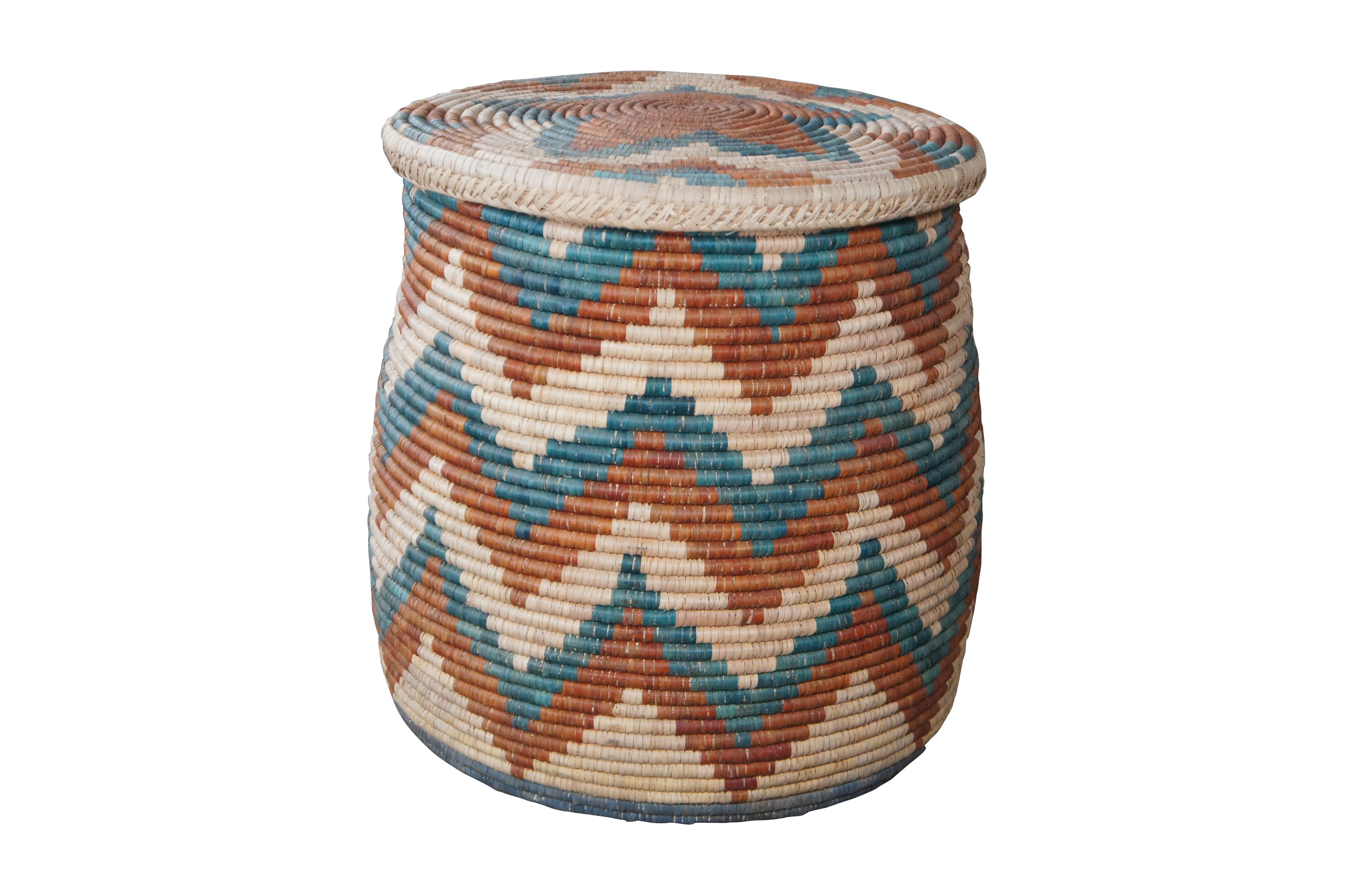 Hand Woven wicker basket or side table. Made from wicker with a green, red and tan zig-zag pattern. The basket is lidded making it perfect for use as a side table with interior storage.

Dimensions:
22